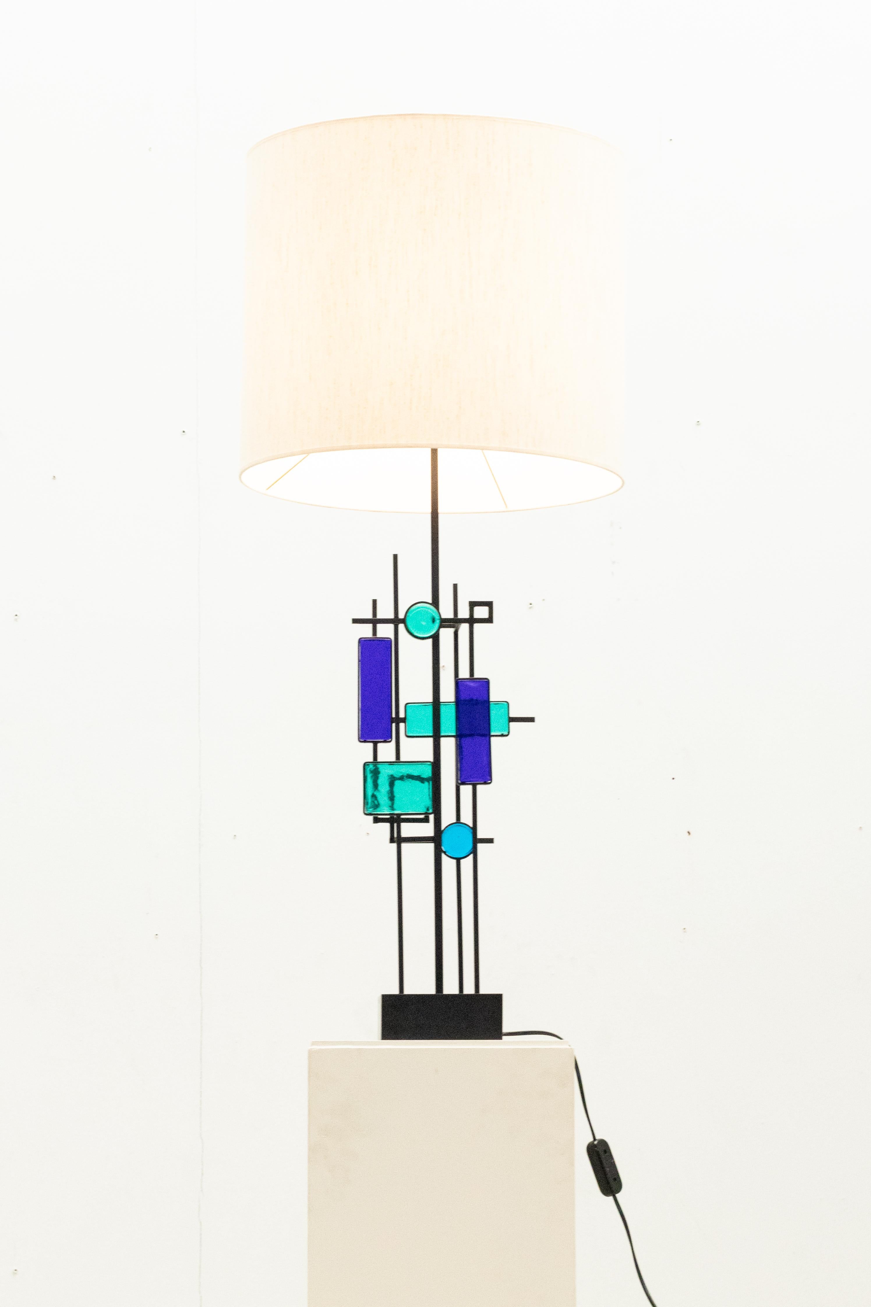 La lampe de table fabriquée en fer et ornée de verre bleu se présente comme un objet de décoration.  création de Svend Aage Holm Sørensen pour Holm Sørensen & Co, datant des années 1960.

Nouvelle teinte.
Excellent état.

N'hésitez pas à nous