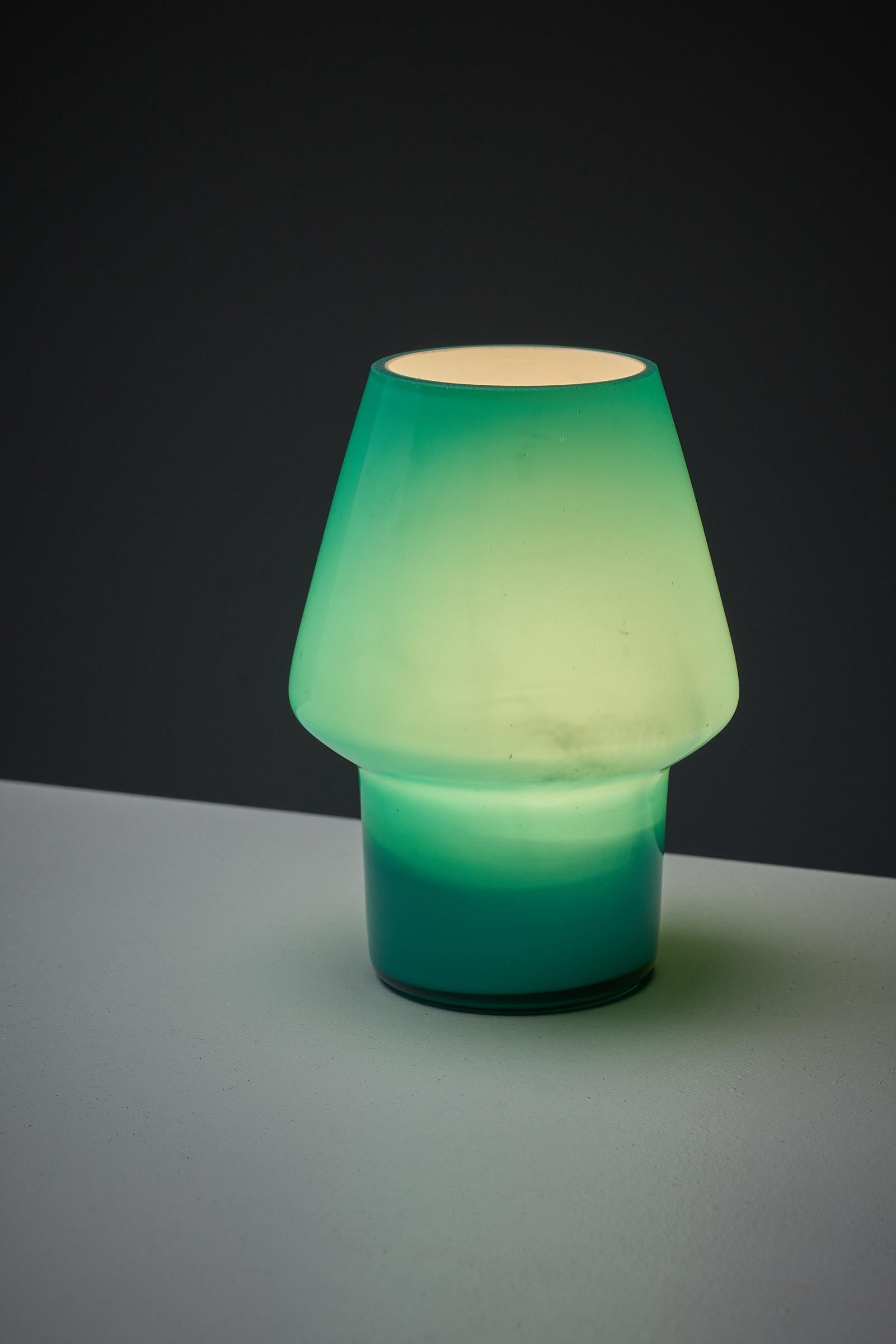 Beautiful glass table lamp. In perfect condition with the original brand sticker still on. The glass is made with a white inner layer to diffuse the light more evenly and has absolutely no chips.
With its beautiful sea green color, this is a very