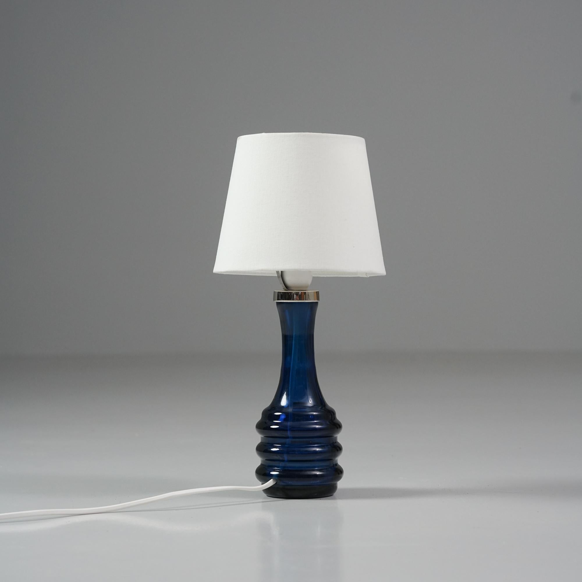 Lampe de table en verre, design Carl Fagerlund, fabriquée par Orrefors, Suède, années 1970. Cadre en verre bleu avec abat-jour en tissu blanc. Bon état vintage, patine mineure correspondant à l'âge et à l'utilisation. 