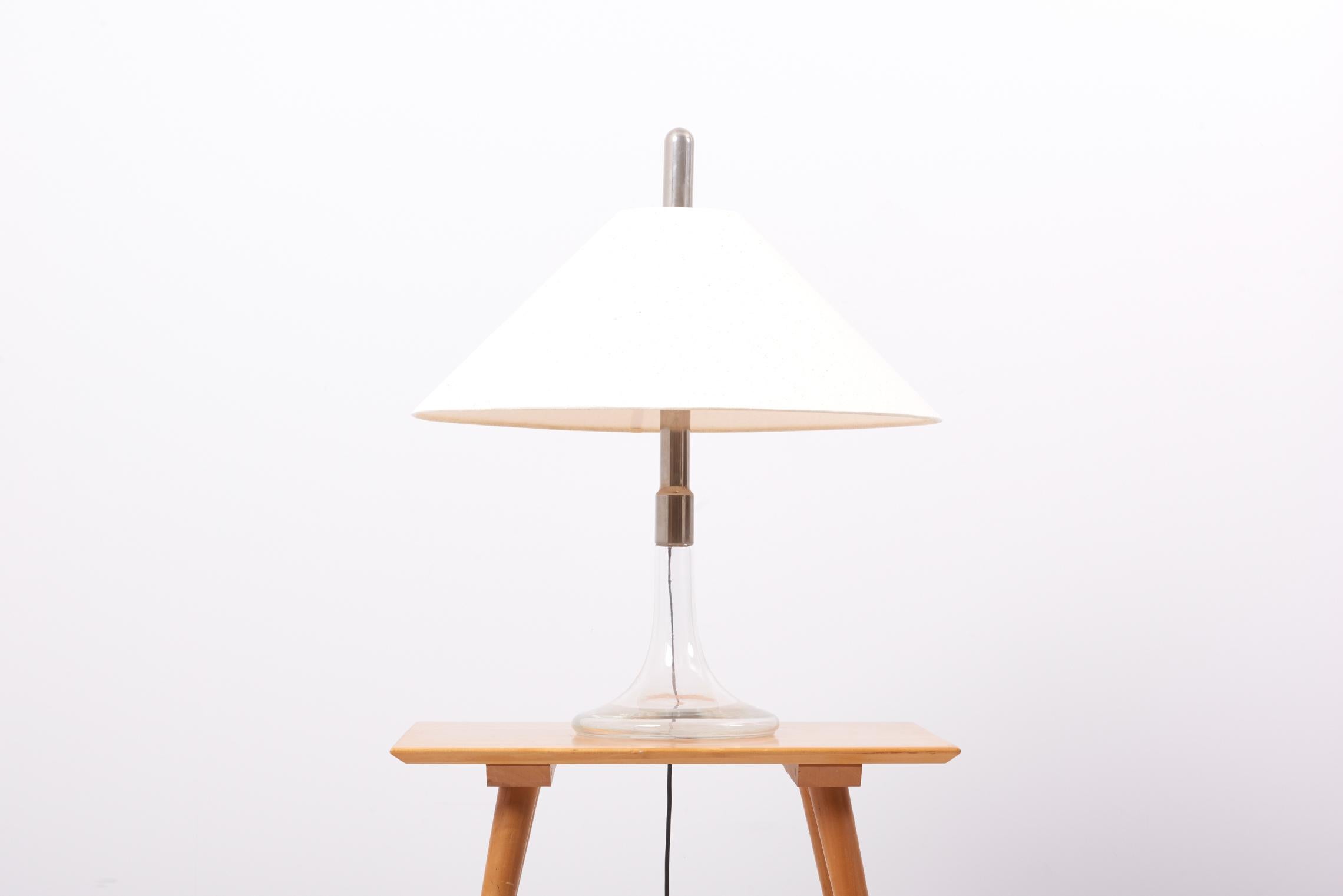 1960s table lamp, model ML3, designed and produced by Ingo Maurer in Germany.
Base made of glass and chrome. Including new lamp shade in beige natural silk.

2 x E27 sockets.

Please note: Lamp should be fitted professionally in accordance to