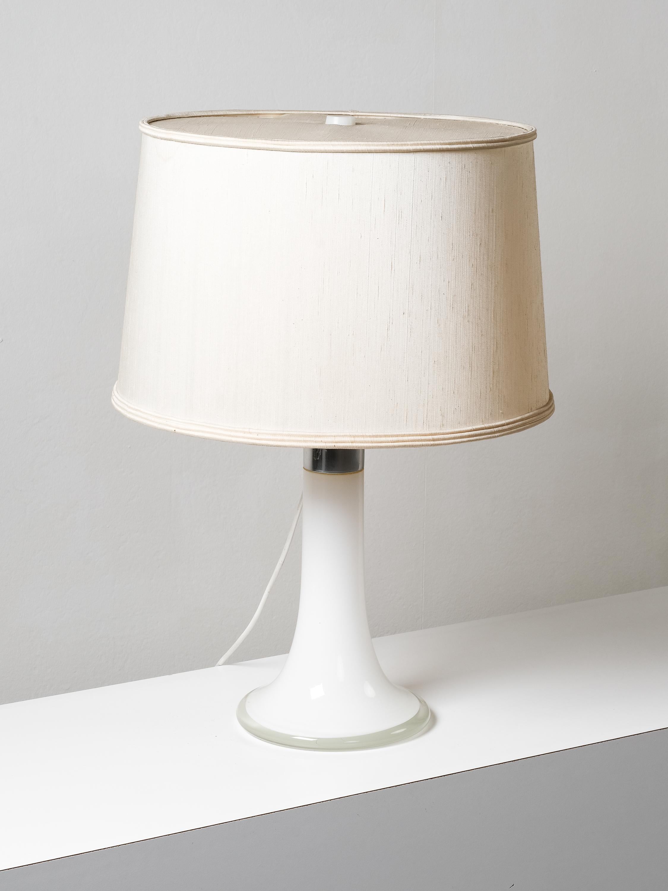 Lampada da tavolo progettata da Lisa Johansson-Pape e prodotta da Orno Oy, anni '60. Gamba in vetro e dettaglio in metallo cromato con paralume originale in tessuto. Buone condizioni d'epoca, alcuni segni dovuti all'età e all'uso.

Porta lampadina