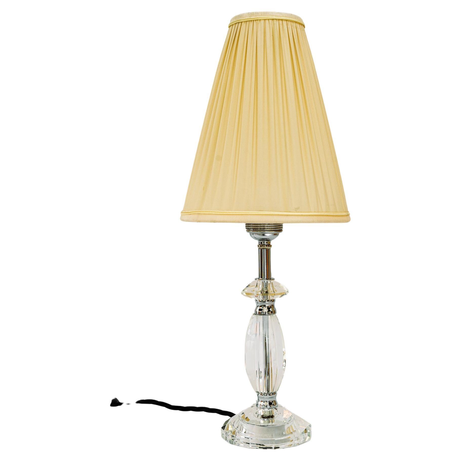 Lampe de table en verre avec pièces chromées et abat-jour en tissu vienne vers les années 1960.