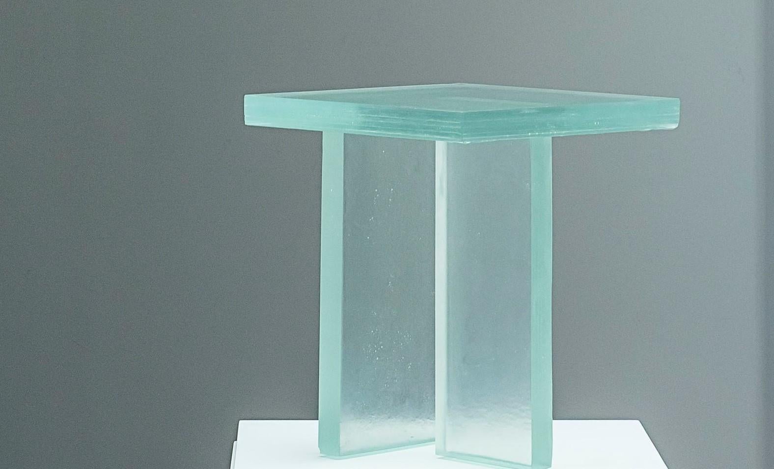 Glass table T by Studio Cas-Lucas Recchia.
Dimensions: W 40 x D 40 x H 40 cm.
Materials: Glass.
Technique: Fusing glass.

Table T is a piece developed at the request of the Iberê Camargo Foundation, responsible for taking care of the work of
