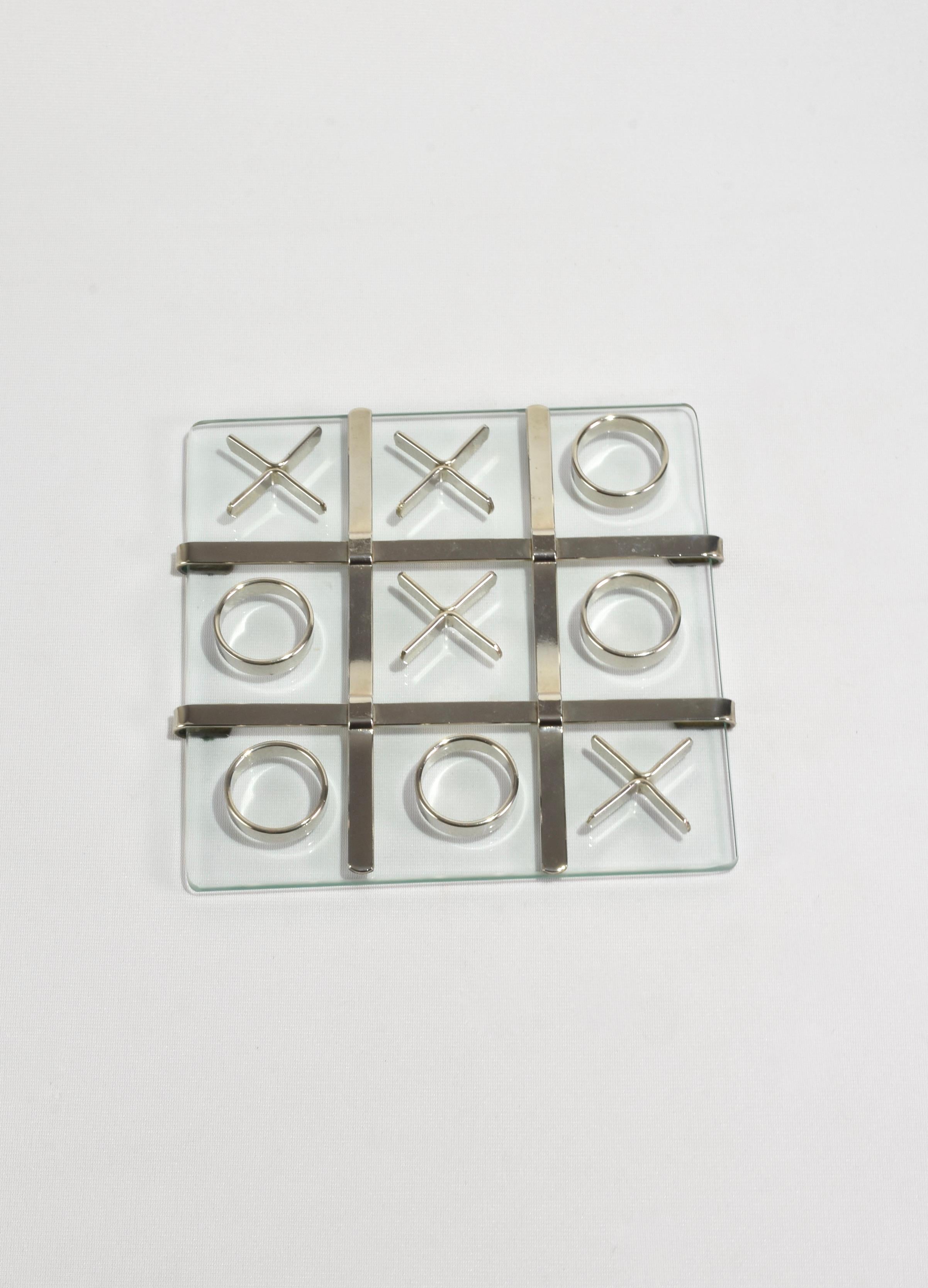 Stunning vintage tic-tac-toe set with a glass base, silver detail and ten silver pieces. One-of-a-kind piece.

Dimensions:
Board measures 8