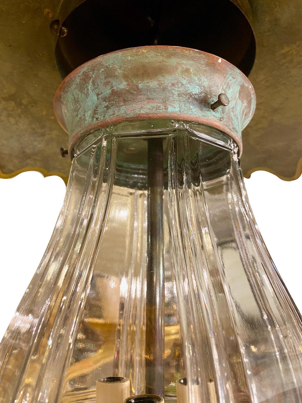 Une lanterne suspendue en verre moulé datant des années 1950 avec trois lumières intérieures en forme de candélabre et un abat-jour peint.

Mesures :
Diamètre 24