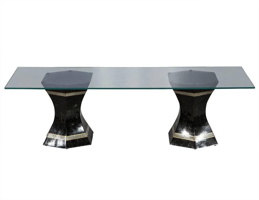 This Neoclassic cocktail table is a perfect example of mixed media.  The glass sits atop two bases, each composed of black and dark grey six-sided marble with two medium grey stripes and gold edges.  A perfect addition to a sophisticated and stylish
