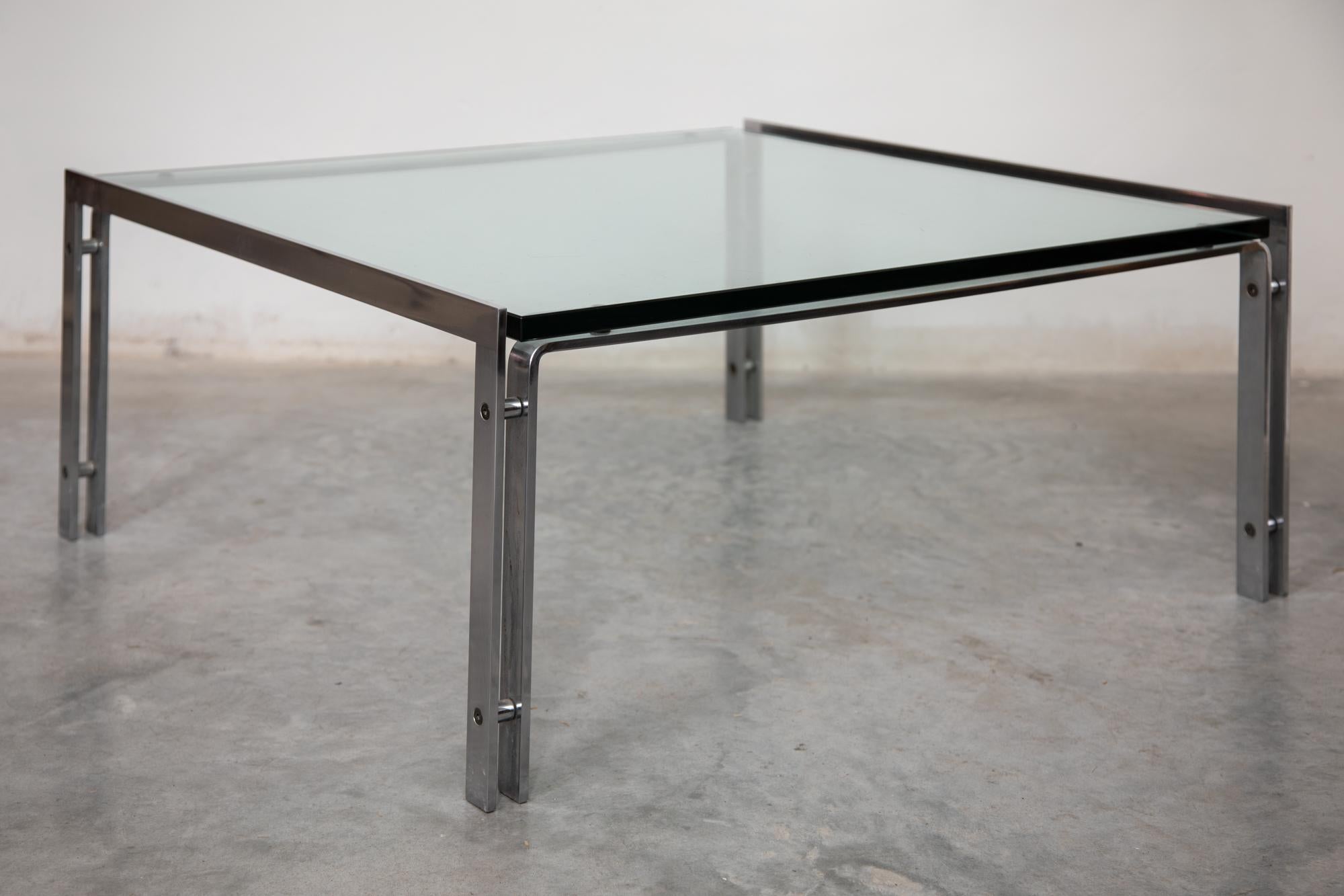 table basse des années 1970, base chromée moderne et minimaliste avec un plateau en verre transparent.


