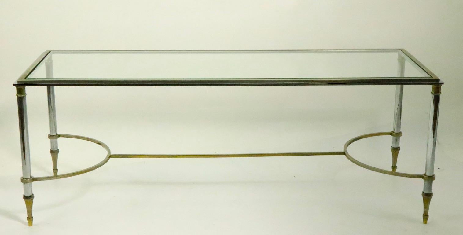 Chic chrome and brass framed, glass top coffee, cocktail table in the style of Maison Jansen probably made in Italy, unsigned, this example is in good, original condition, showing only light cosmetic wear to finish, normal, and consistent with age.