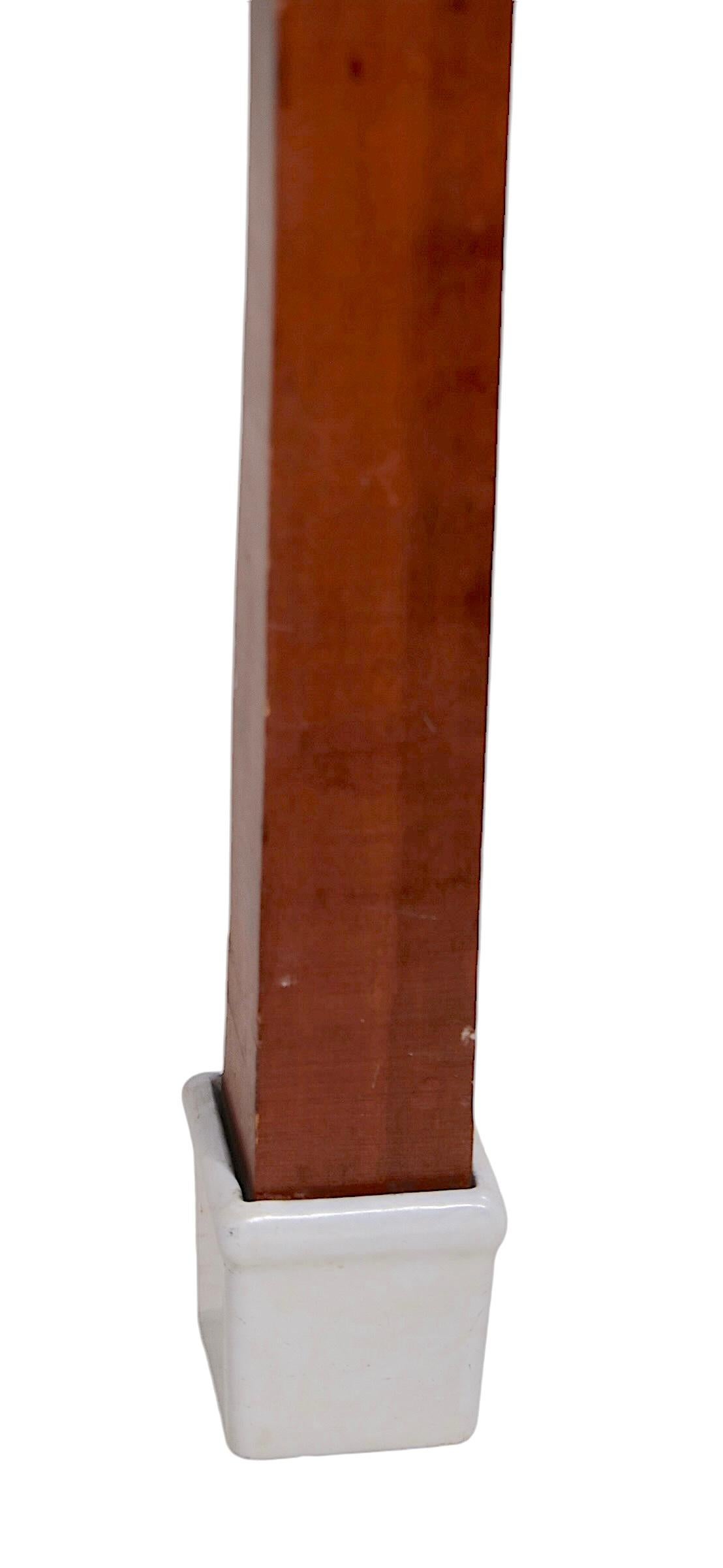 Charmante table de pâtissier vintage du début du 20e siècle avec un plateau en verre au lait épais ( 1 pouce ), une base en bois massif et des pieds en porcelaine émaillée de type botte. Conçue à l'origine comme table de travail dans une cuisine