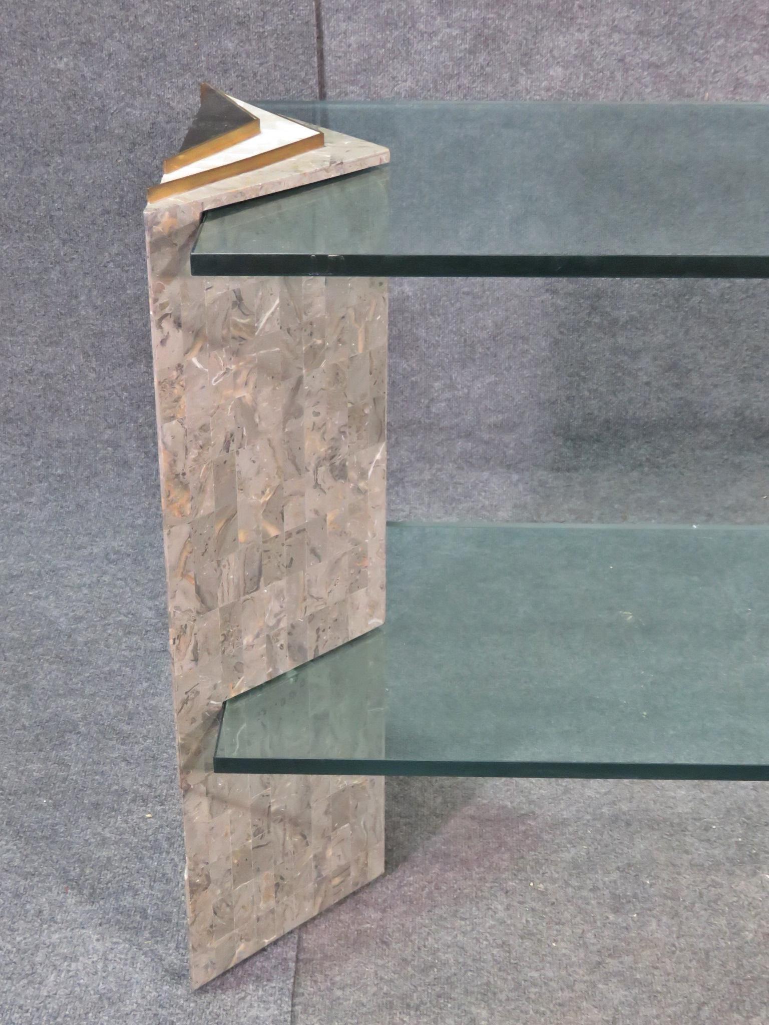 A Mid-Century Modern console table that features an eye-catching combination of stone, mother-of-pearl, brass, and glass. Styled after iconic furniture designers Maitland-Smith. Please confirm item location with seller (NY/NJ).