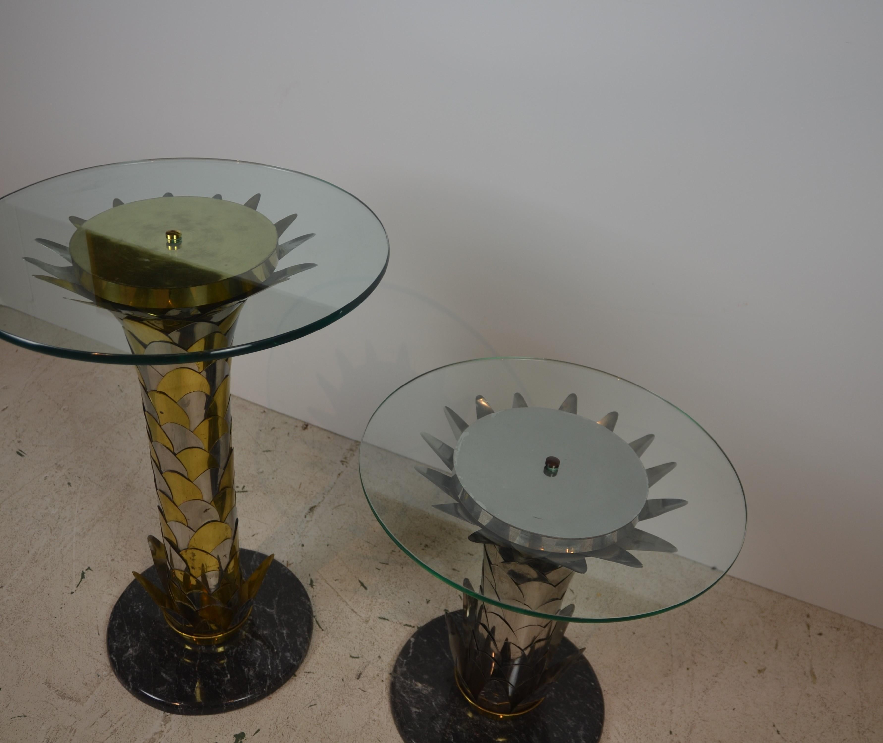 Round shape glass top, brass, chrome pedestal, and round marble base. The tables are not the size. Measures: The small table is 20