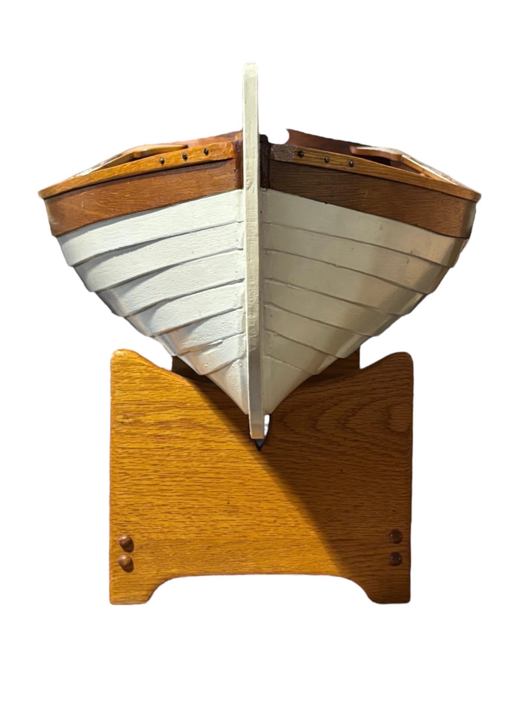 Mesa de centro artesanal con tablero de cristal incrustado. El barco está hecho de roble, caoba y madera contrachapada con tornillos de bronce, pintado de blanco tradicional en el exterior con un interior natural. Viene con el soporte original de
