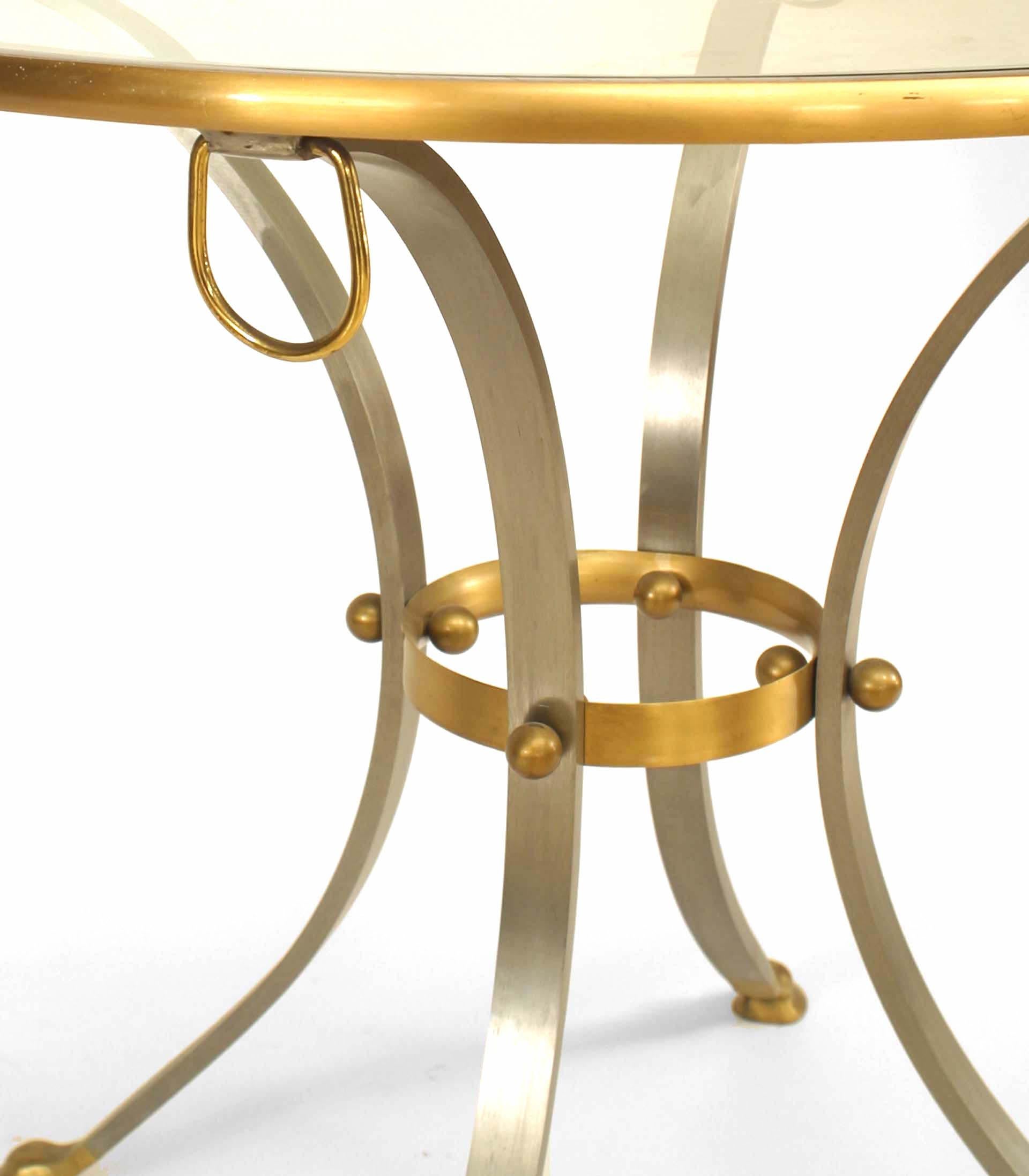 Art Moderne style (1960's) steel round center table with glass top and bronze edging and ball and ring detail culminating in cloven feet.
