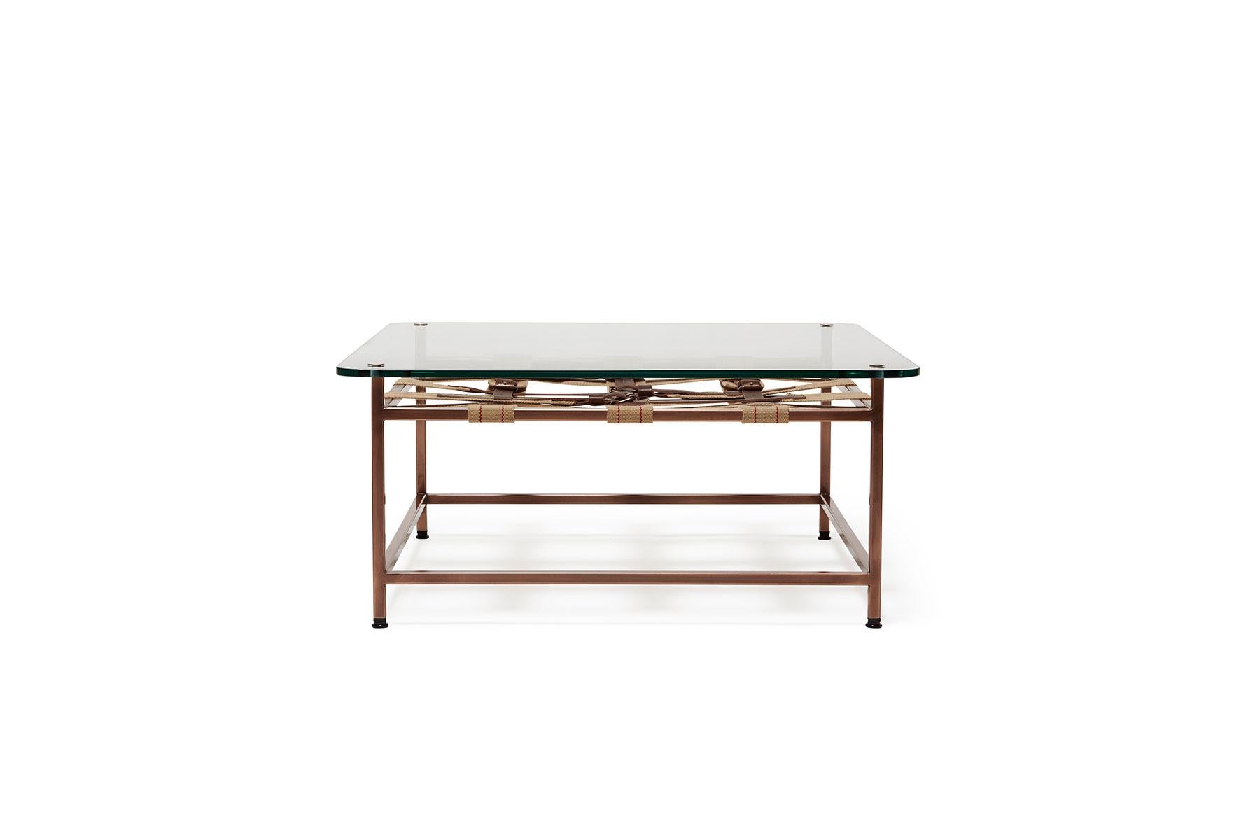 This glass-topped coffee table utilizes the signature belts from the Stephen Kenn Inheritance Collection stretched across an antique copper-plated steel frame. The belts are a replica of a WWII Swiss army 