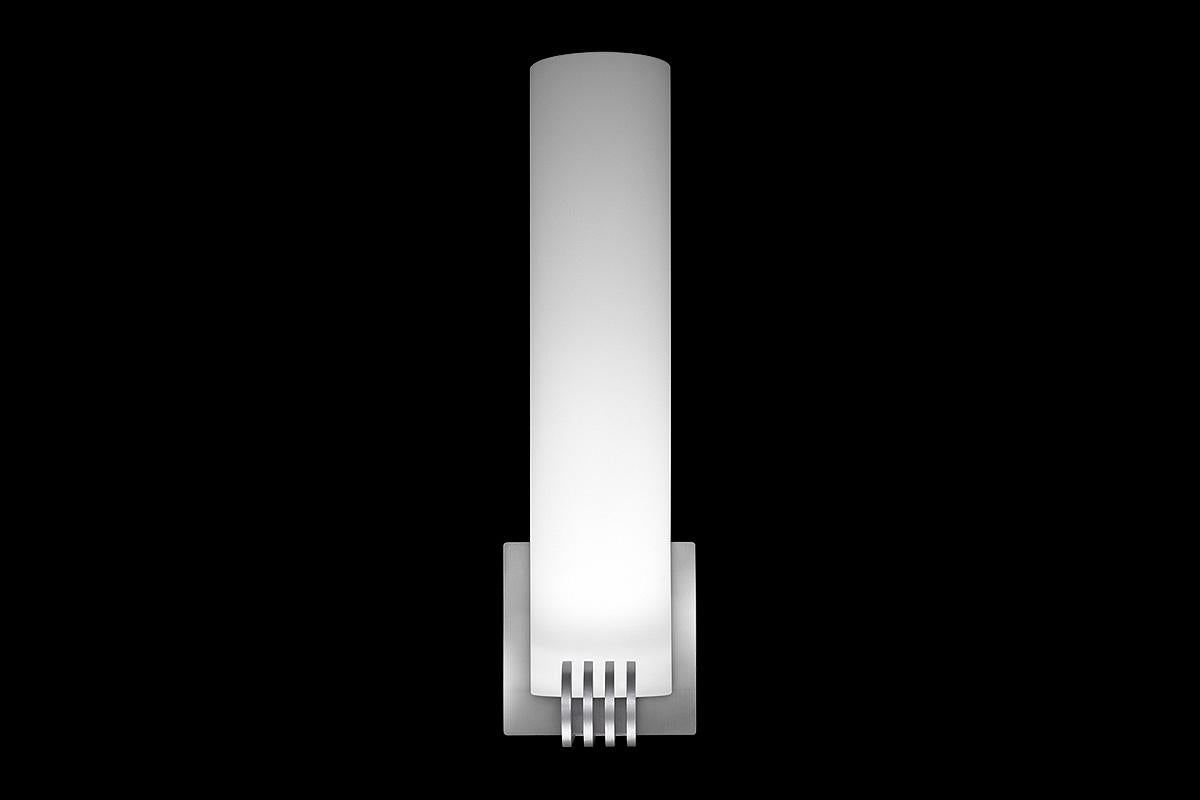 Glass tube shade with machined aluminum holder. Metal fins in the manner of streamline moderne. LED lamping, standard color temperature 3000k.

Architect, Sandy Littman of Duesenberg LTD. and The American Glass Light Company have been making