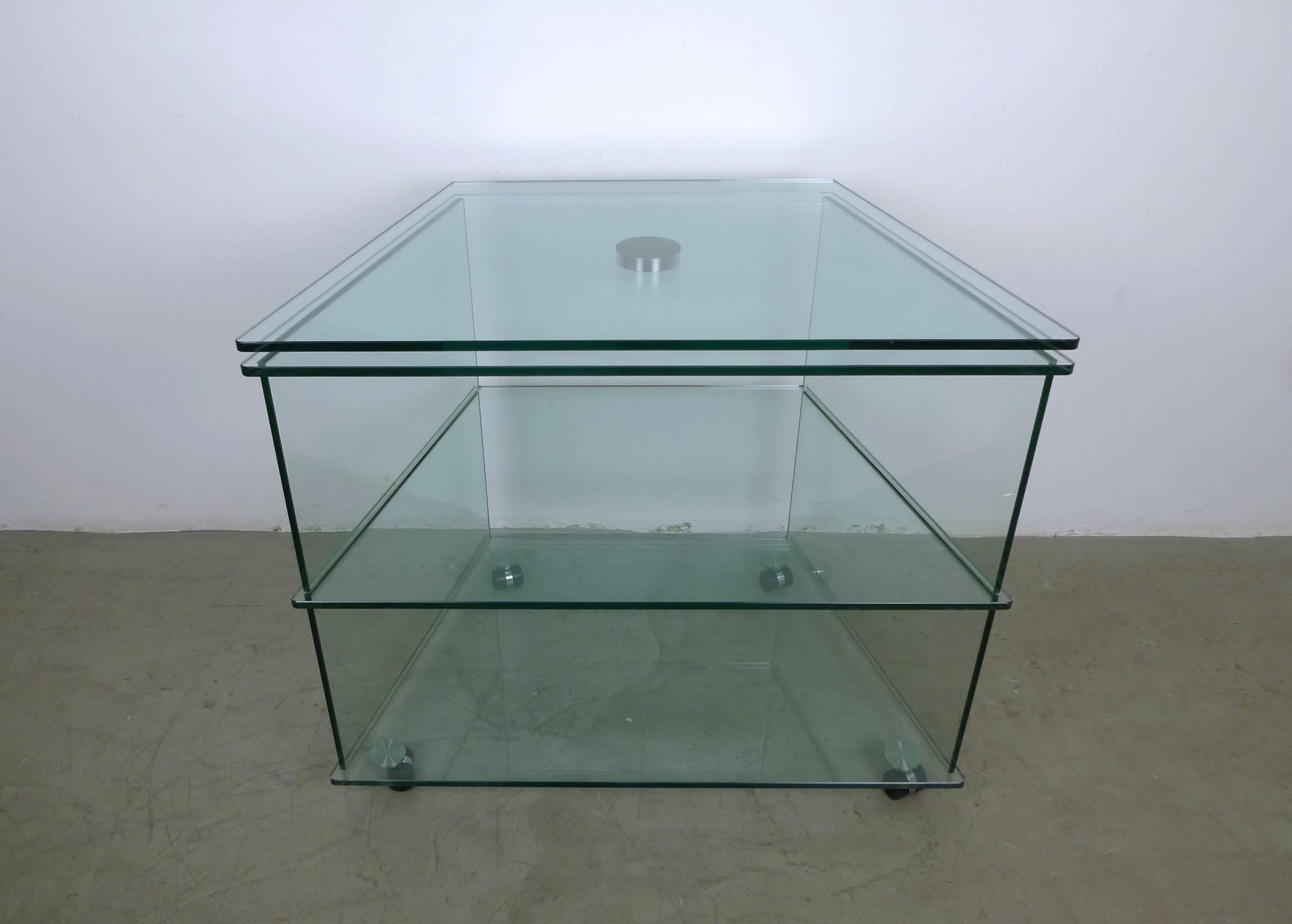 Glass TV stand on wheels, Germany, 1970s. This large TV stand is made of glass and features a swivel top, two compartments, and rests on four wheels. The trapezoidal frame is wider at the front (85 cm) and tapers back to a width of 55 cm.
The media