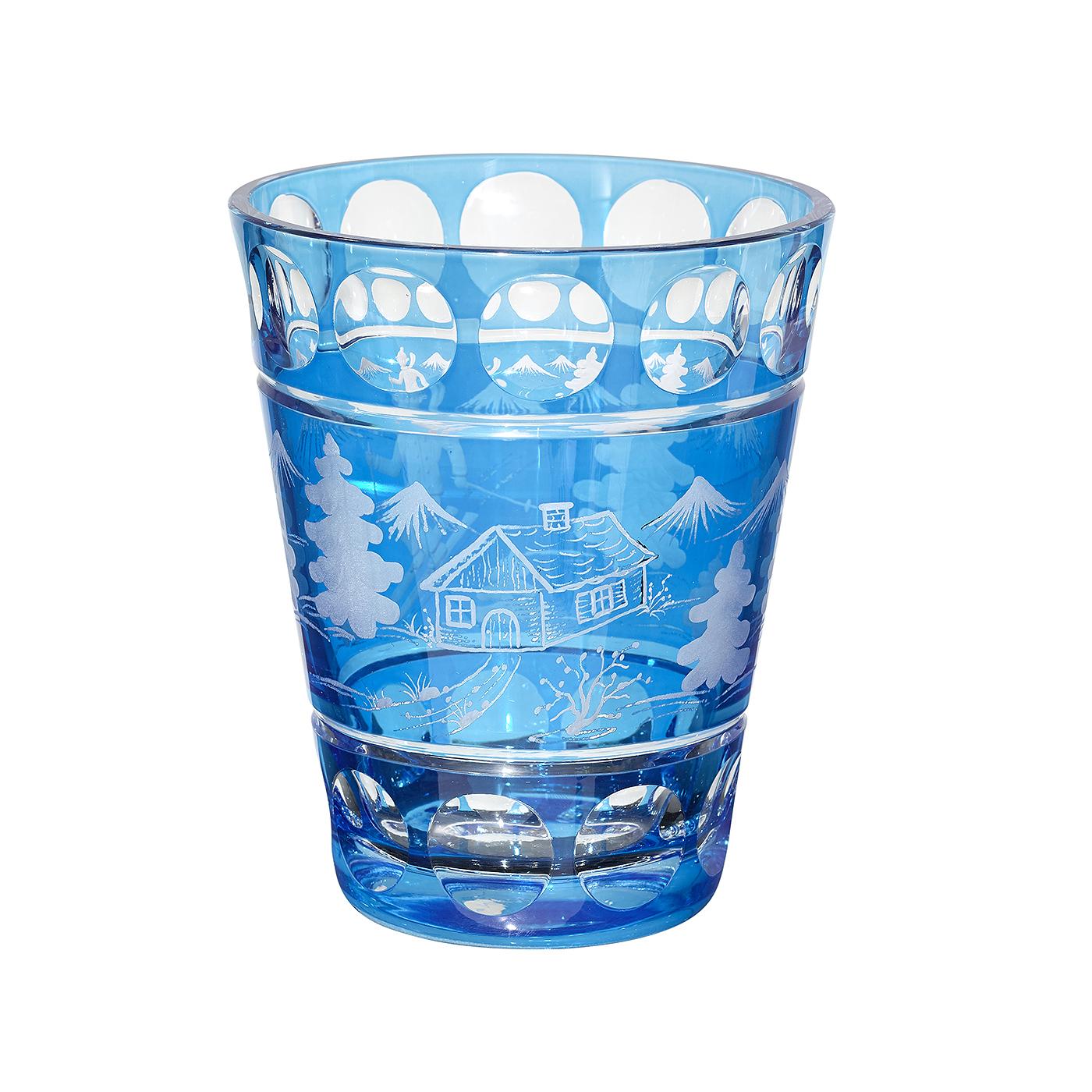 Vase en verre soufflé à la bouche, en cristal bleu, avec décor de skiier plié à la main. Le décor est celui d'un skieur avec des arbres, des montagnes et une cabane gravés tout autour. Entièrement soufflé et gravé à la main en Bavière, en Allemagne.