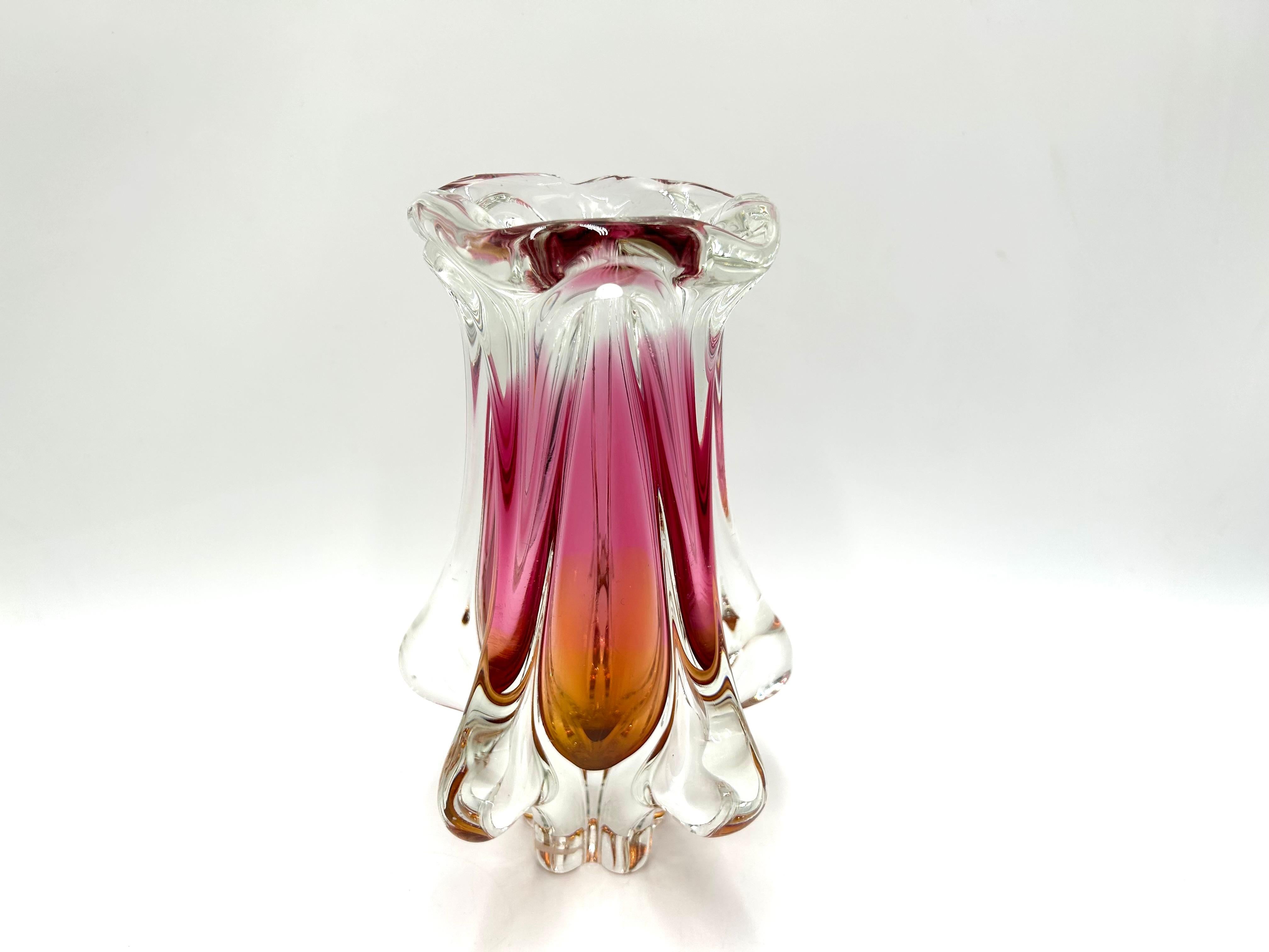 A glass vase with a unique shape in beautiful shades of pink with orange

Produced in the Czech Republic in the 1960s in Huta Chribska.

Very good condition, no damage

height: 23cm

diameter: 11cm.