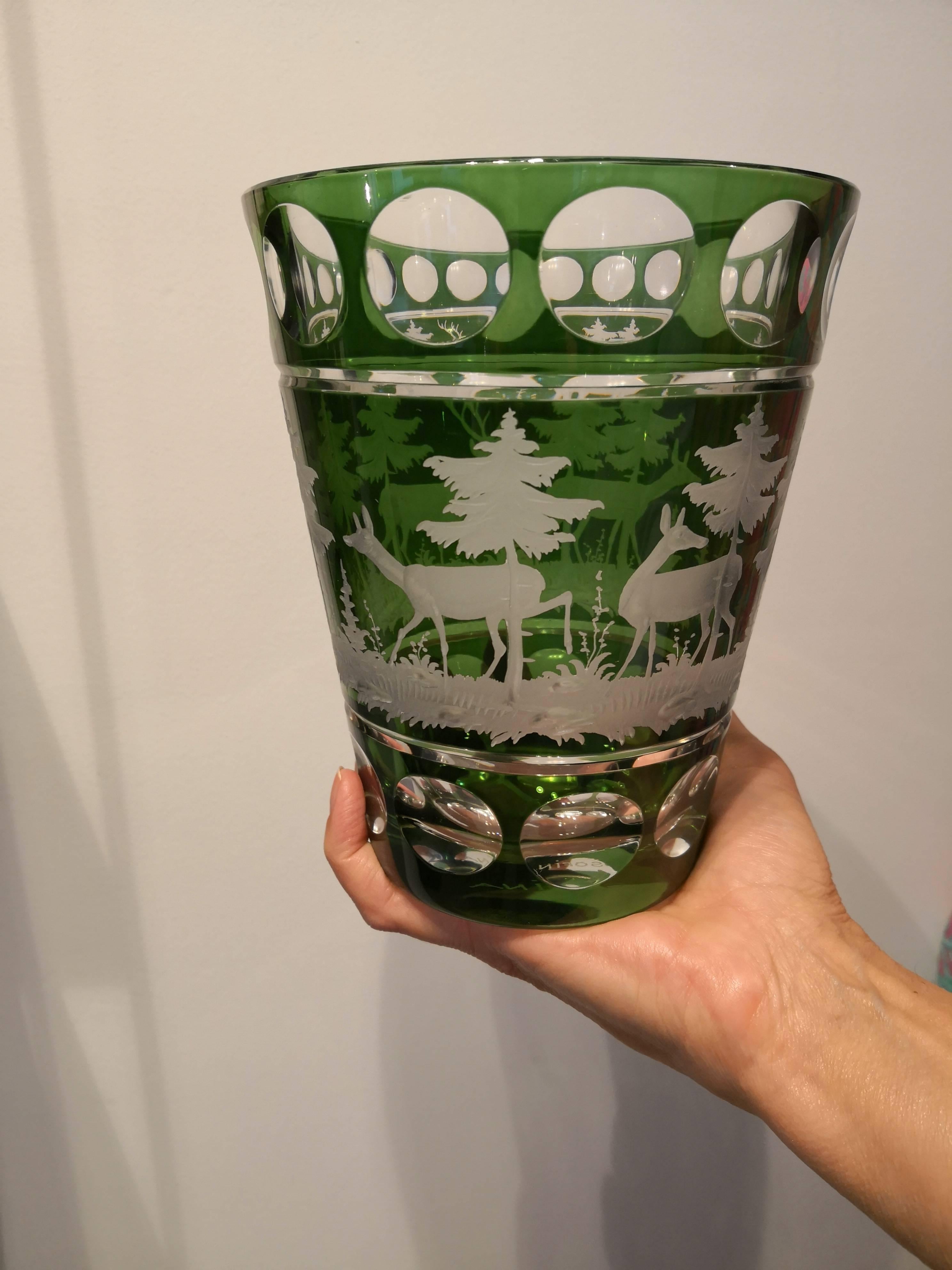 Vase en cristal soufflé à la bouche en verre vert avec une scène de chasse gravée à la main dans le style de la forêt noire. Le décor est un décor antique avec des cerfs, des arbres et des bambis tout autour. Entièrement soufflé et gravé à la main