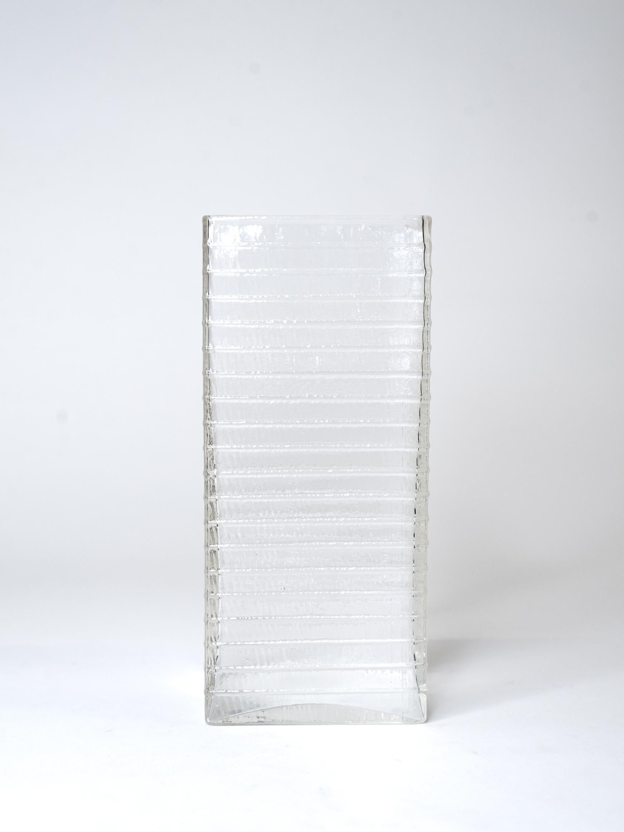 A stunning example of Kaj Franck’s minimalist genius, this tall rectangular vase was designed for Nuutajärvi in the late 1960’s. With its clean lines, architectural silhouette and subtle horizontal ribbing, the vase reflects Franck’s commitment to