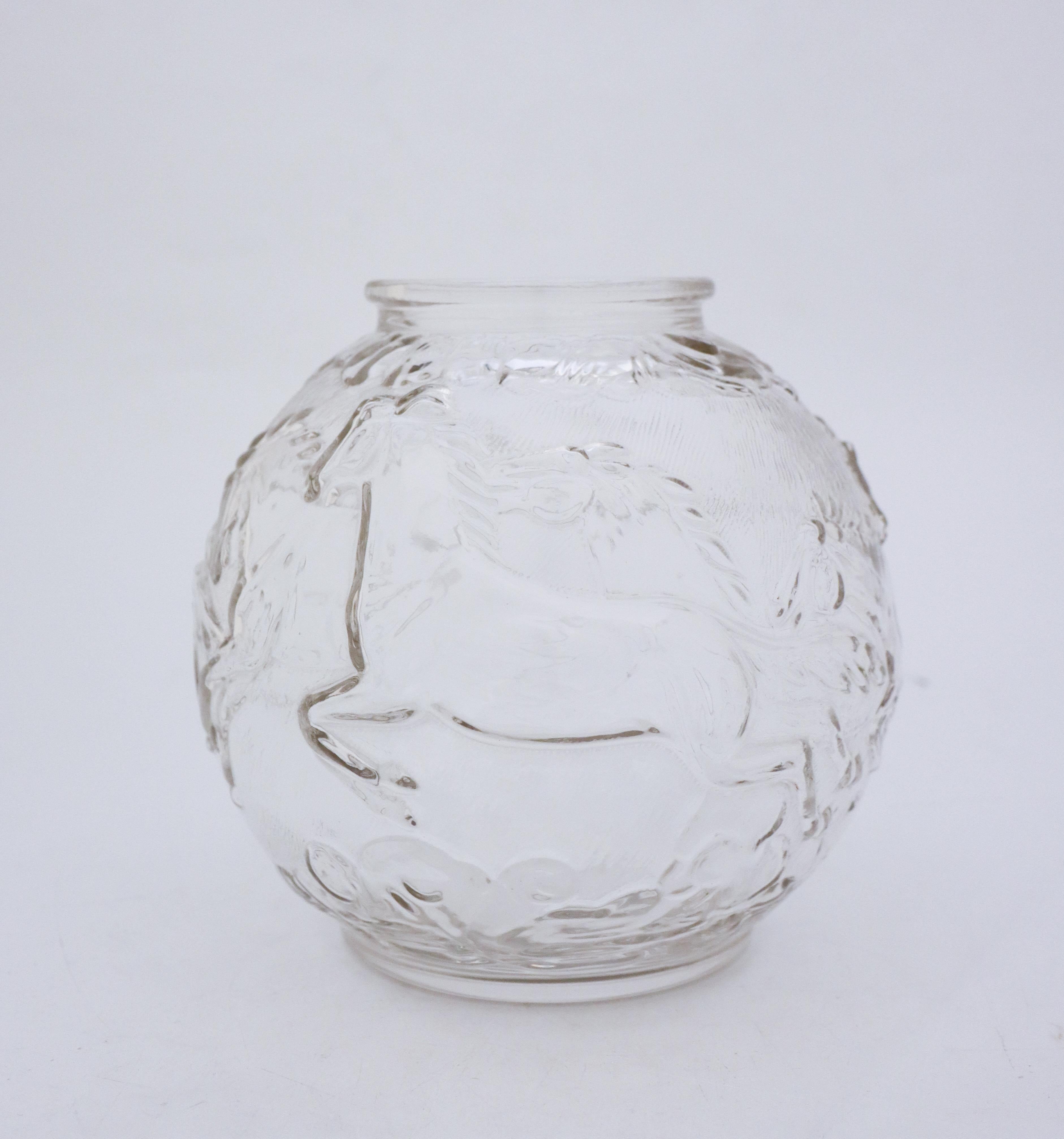 A stunning round globe vase in glass designed by Edvin Ollers at Glimma Glass works in the 1950s. It is 18 cm in diameter and about 18 cm high. The vase is in transparent glass with a decor of horses, it is molded. It is in very good condition, it