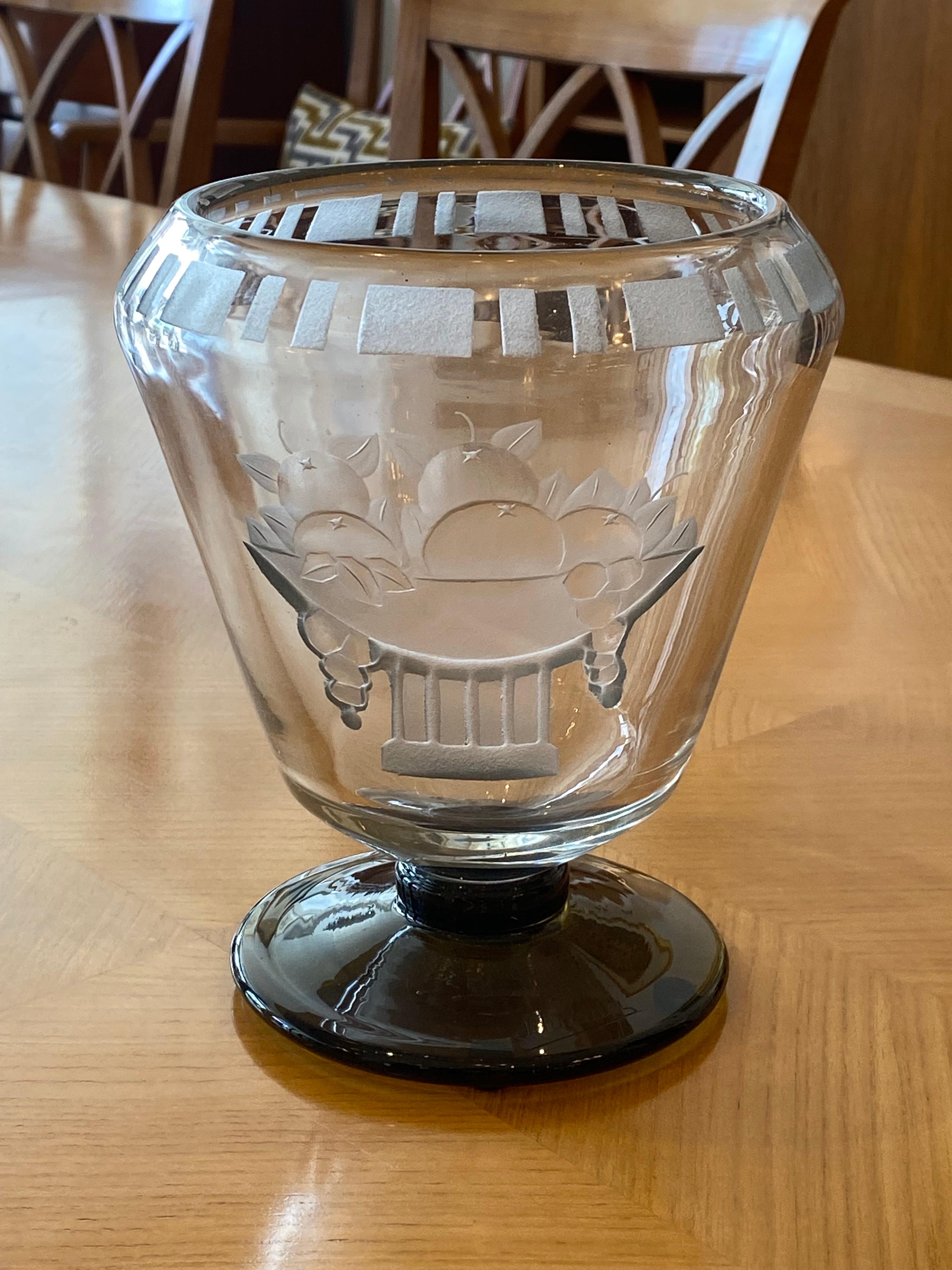 A Clear glass coupe-shaped vase with a fruit basket motif in sandblasting technique, retouched by wheel-carving.  Foot in Grey in powdered glass. 
This piece is from the Corbeille serie of Charles Schneider.
Signed by Charles Schneider.

Charles