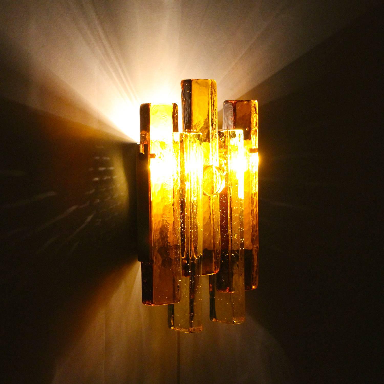Glass wall light by Hassel & Teudt in the 1960s, Danish Mid-Century Modern amber glass and brass wall lamp in excellent vintage condition.

A beautiful wall lamp, made up of hand molded glass rods, layered and arranged in a rectangular design and