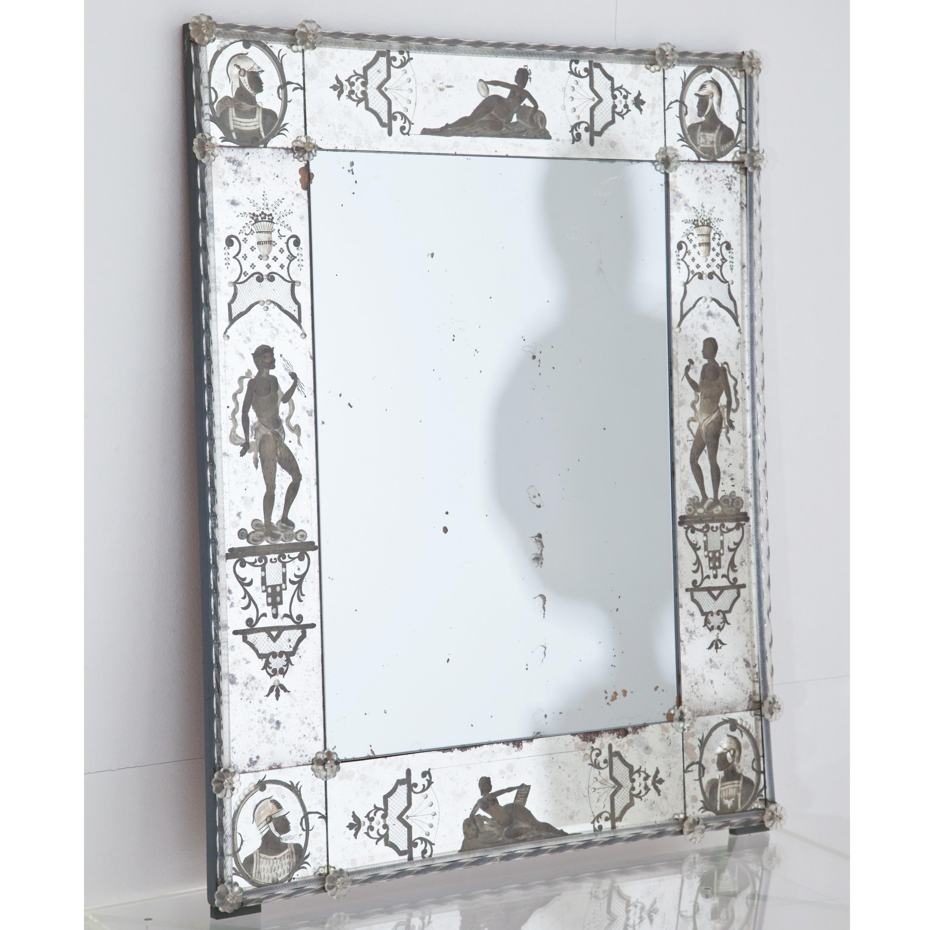 Rectangular wall mirror with a narrow frame and floral decoration out of glass and etched figure decorations around the edge. The mirror glass is blind in places.