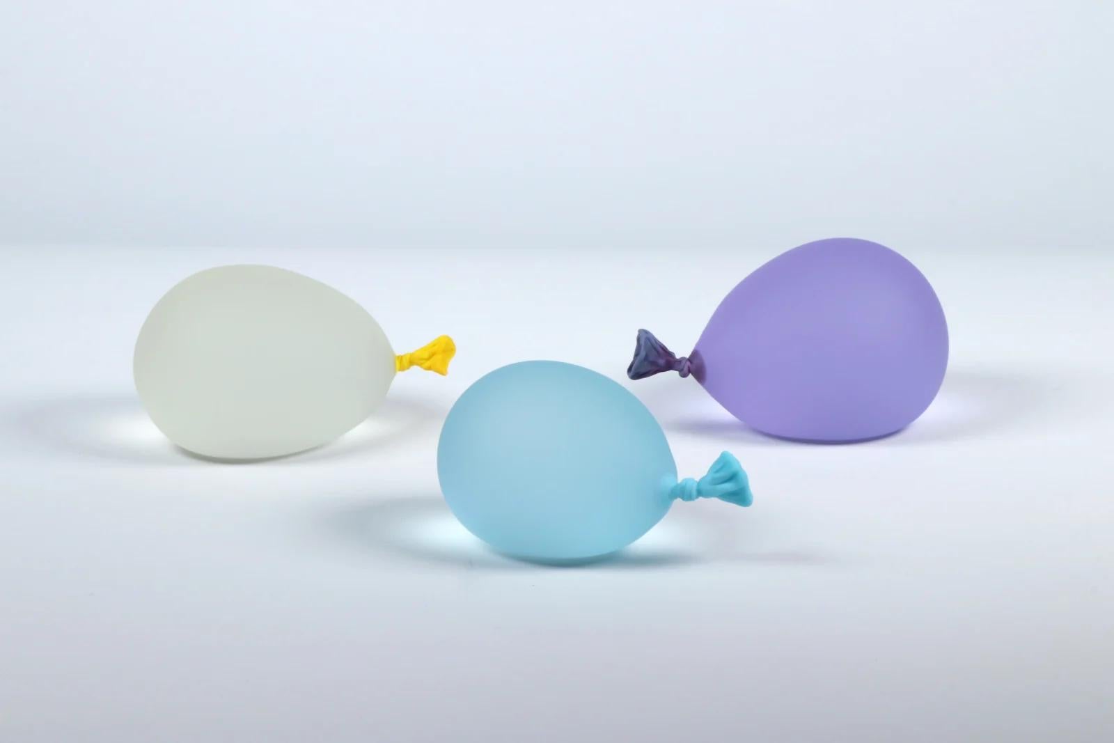 Los globos de agua hiperrealistas de Dylan Martinez están hechos de vidrio macizo esculpido, pulido con chorro de arena y grabado al ácido para que parezcan globos de agua reales. Las esculturas se hacen en pequeños lotes, y cada color se mezcla a