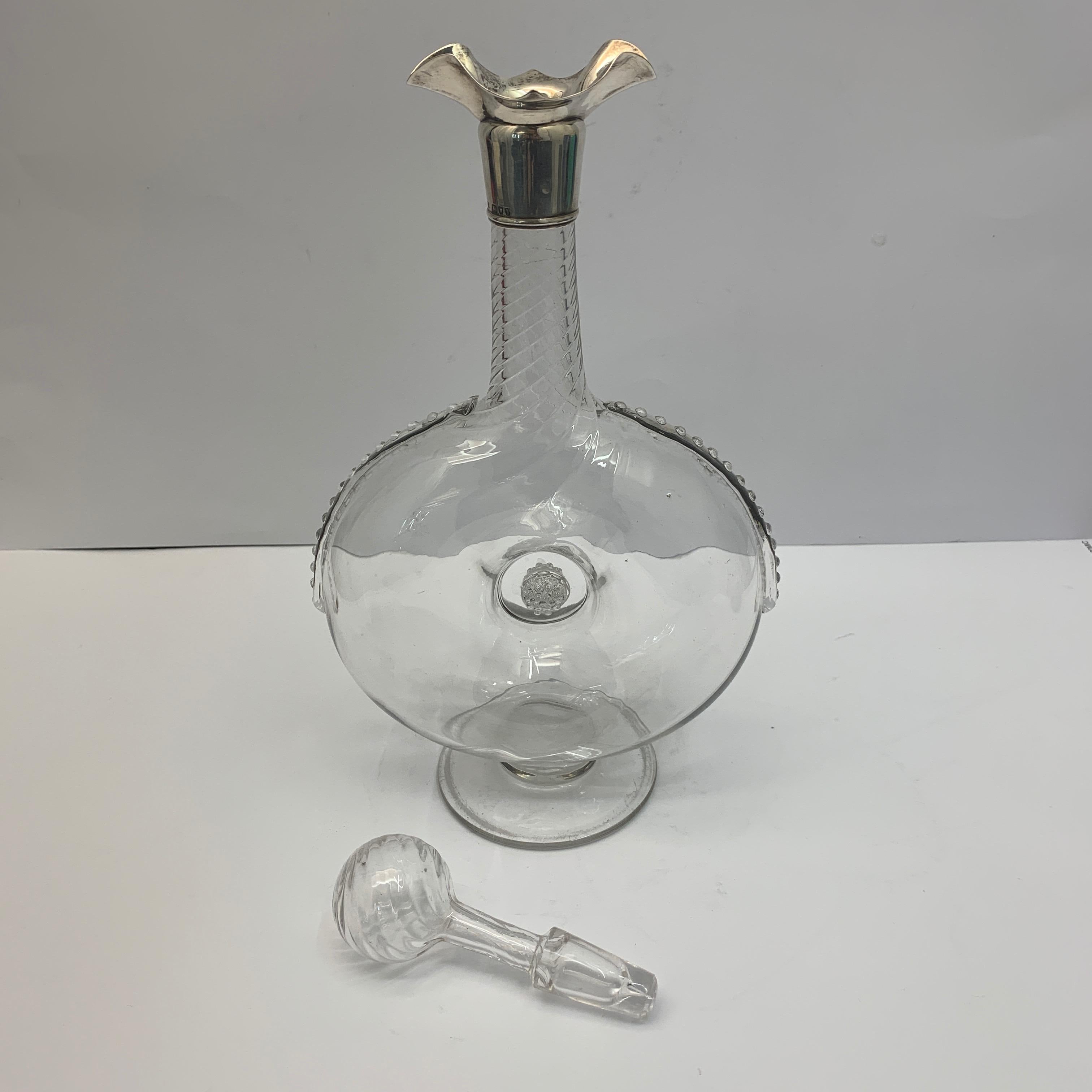 A glass wine decanter with delicate decoration and fully hallmarked, fluted silver rim pourer, finished with a spherical glass stopper. London, 1894. 

(Measurements shown are height including stopper).