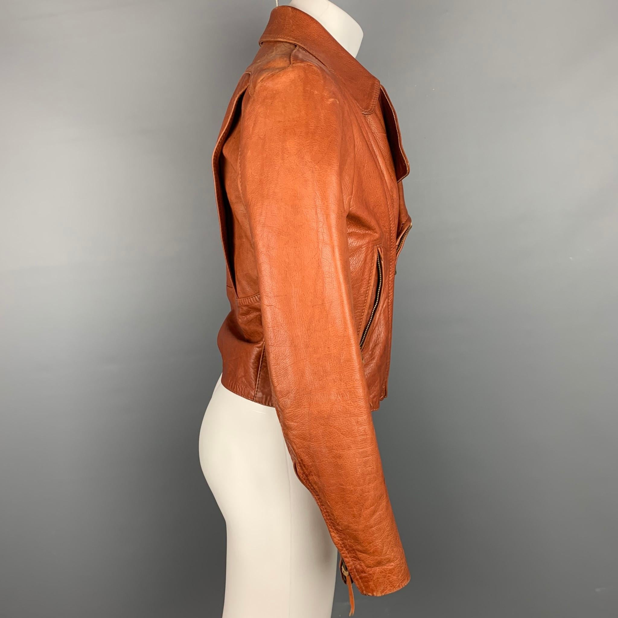 Vintage 70's GLASSWATER jacket comes in a cognac leather with a full liner featuring a motorcycle style, notch lapel, zipper pockets, and a zip up closure. Minor wear. As-Is.

Good Pre-Owned Condition.
Marked: No size
