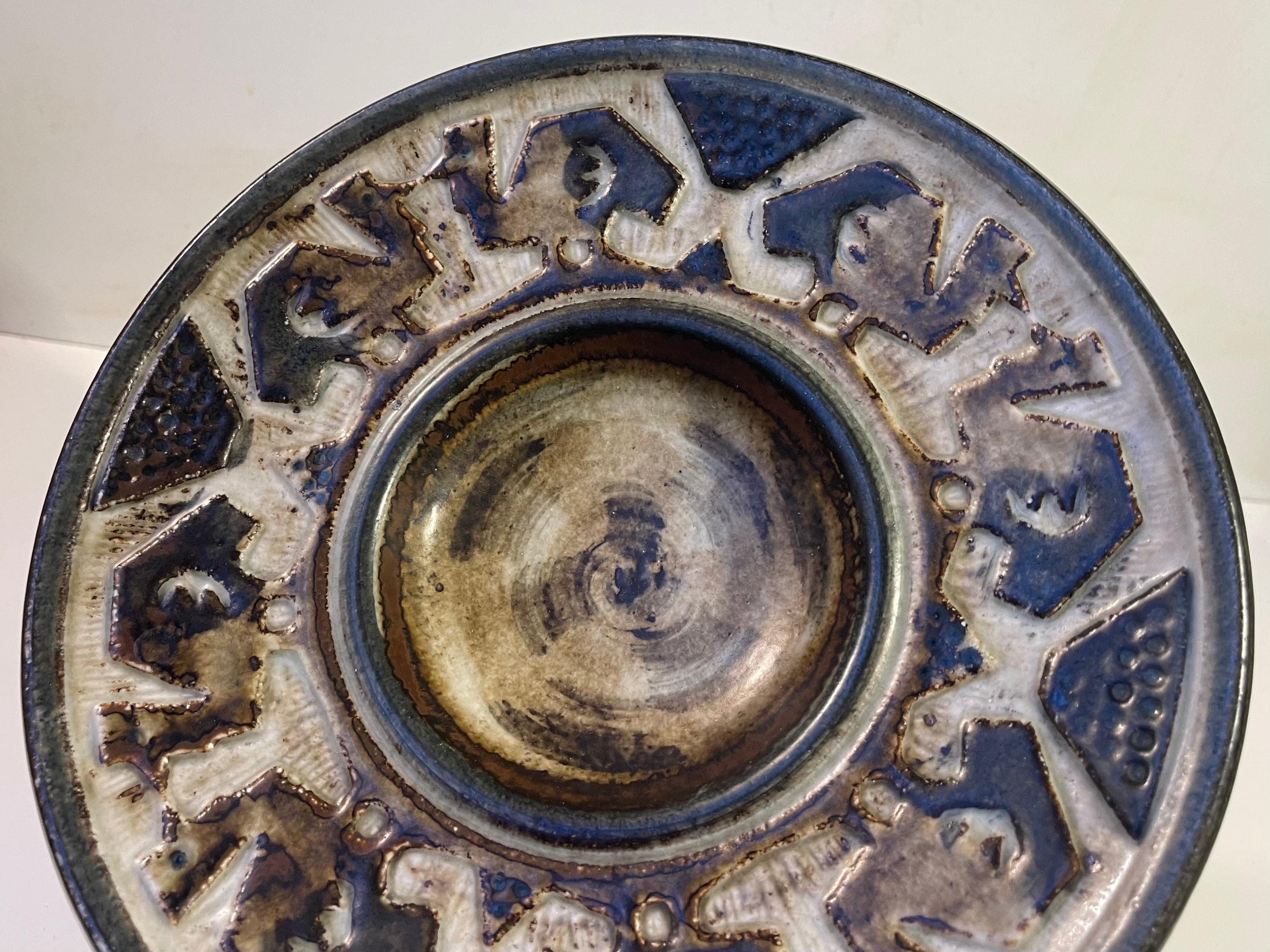 Dish or bowl by the danish ceramist Jørgen Mogensen. Stoneware with earthy glazes and with geometric relief featuring camels or birds. JM commemorates such Royal Copenhagen designers as Axel Salto and Bode Willumsen particularly in his choice of