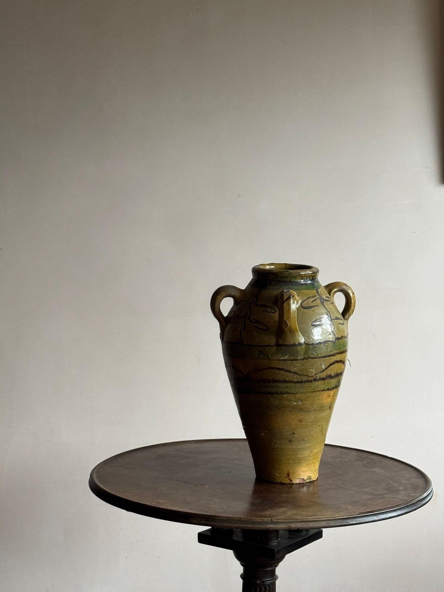 An olive green glazed and decorated vessel with four handles. C.1900 Southern European. 
Dimensions:
H 40cm
W 28cm
D base 11.5cm