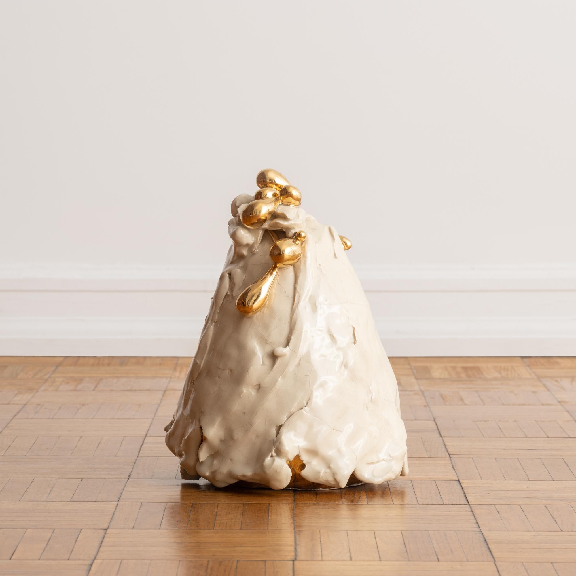 'Untitled' by Ivana Brenner, is a one-of-a-kind, contemporary hand-molded ceramic sculpture. Its surface is encased in gestural layers of glossy cream-colored glaze, with 22k gold luster meticulously applied in mesmerizing globs that shimmer and