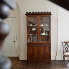 Glazed antique mahogany bookcase with crenelated cornice, by James Winter & Sons