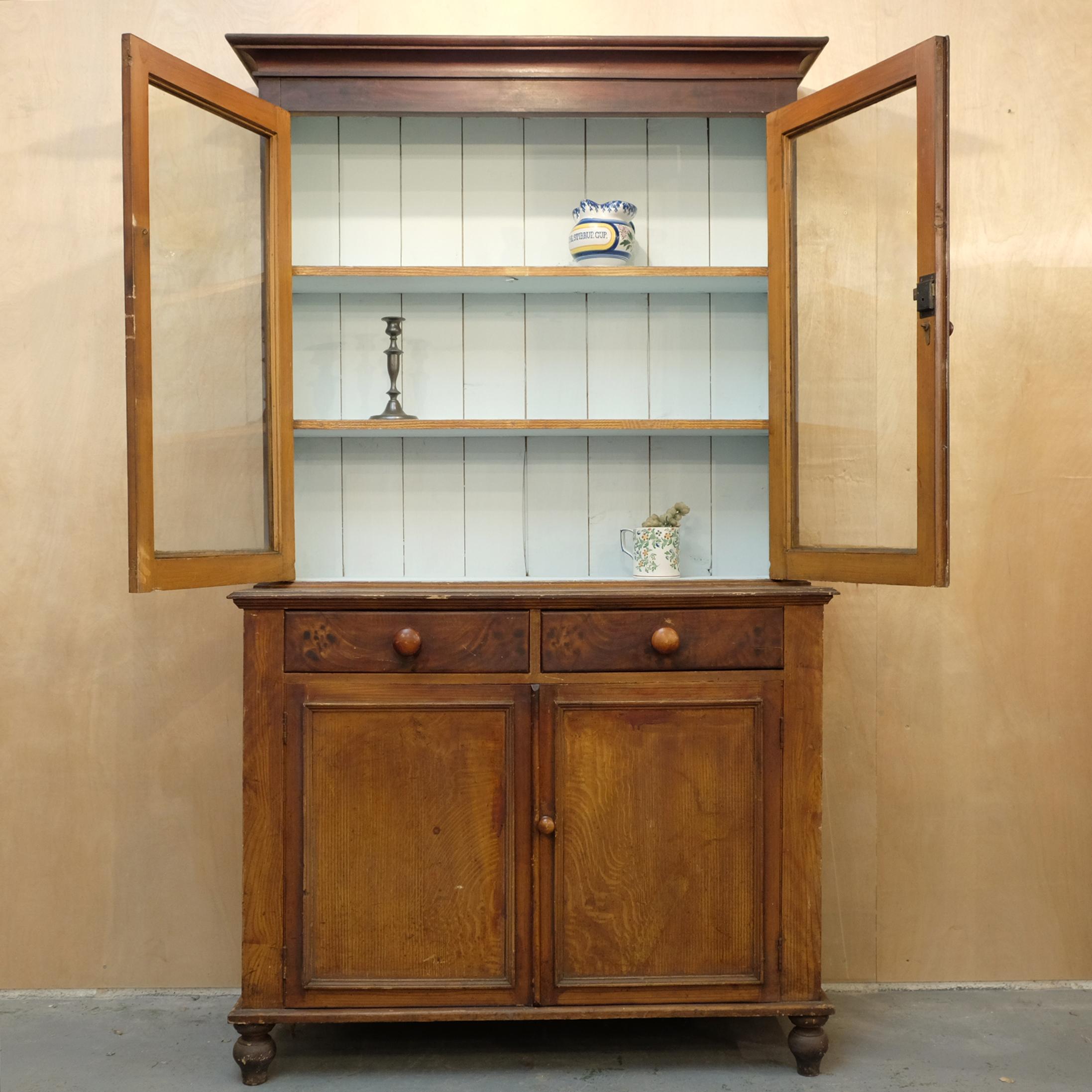 Victorian glazed pine bookcase or dresser in original combwork finish. Two-door cupboard under two drawers to the lower half. The upper half with two glazed doors and painted shelved interior. The original handmade glass with characterful air