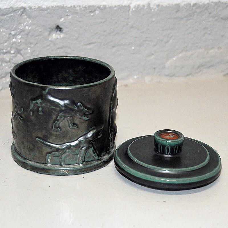 Unique petite boîte à couvercle en céramique suédoise émaillée verte mod 39 par Einar Luterkort pour Upsala-Ekeby, Suède, années 1930. Superbe mélange de couleurs vertes et d'oxyde de cuivre charbonneux avec effet de patine et motif en relief d'un