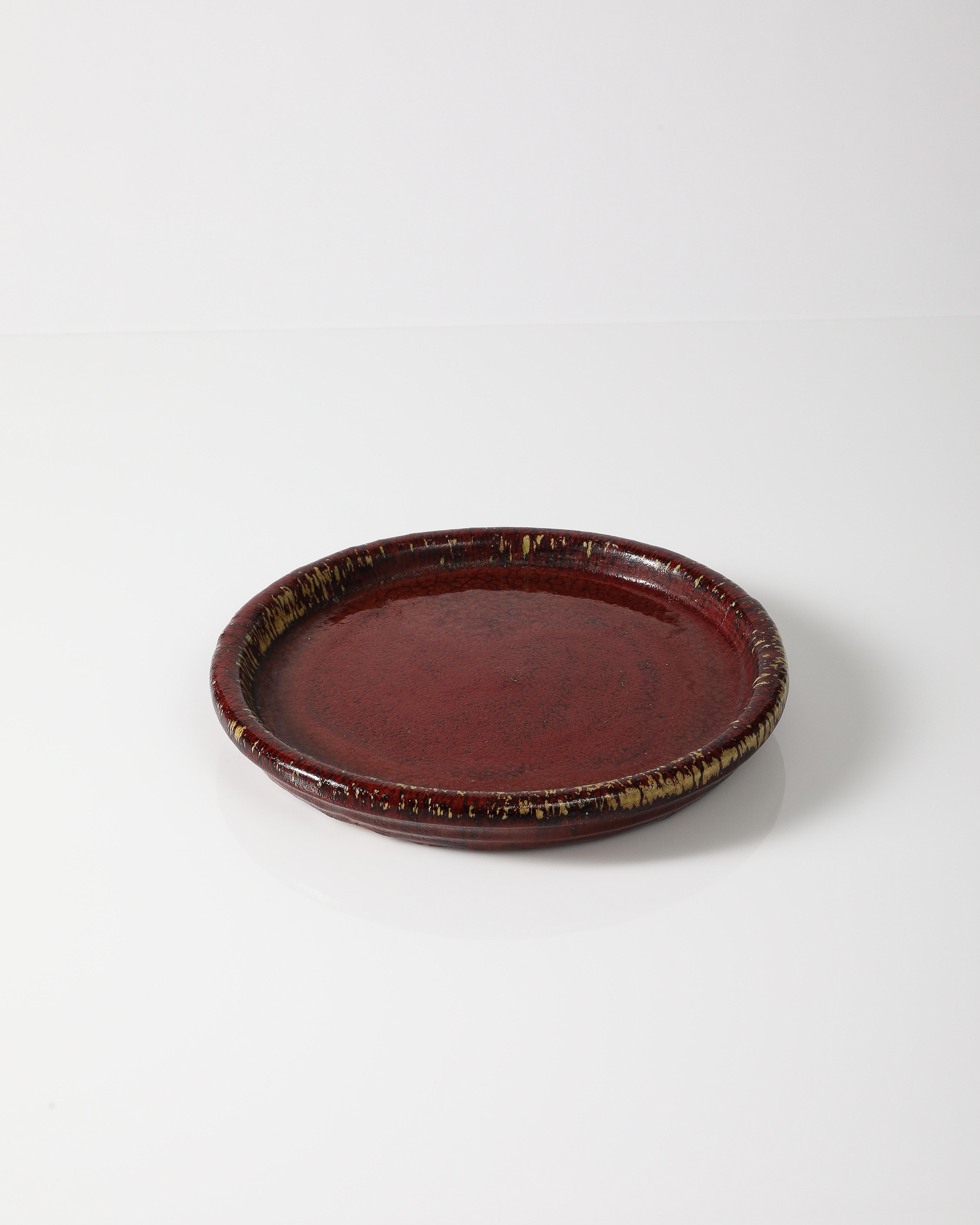 Piatto in ceramica smaltata bordeaux.