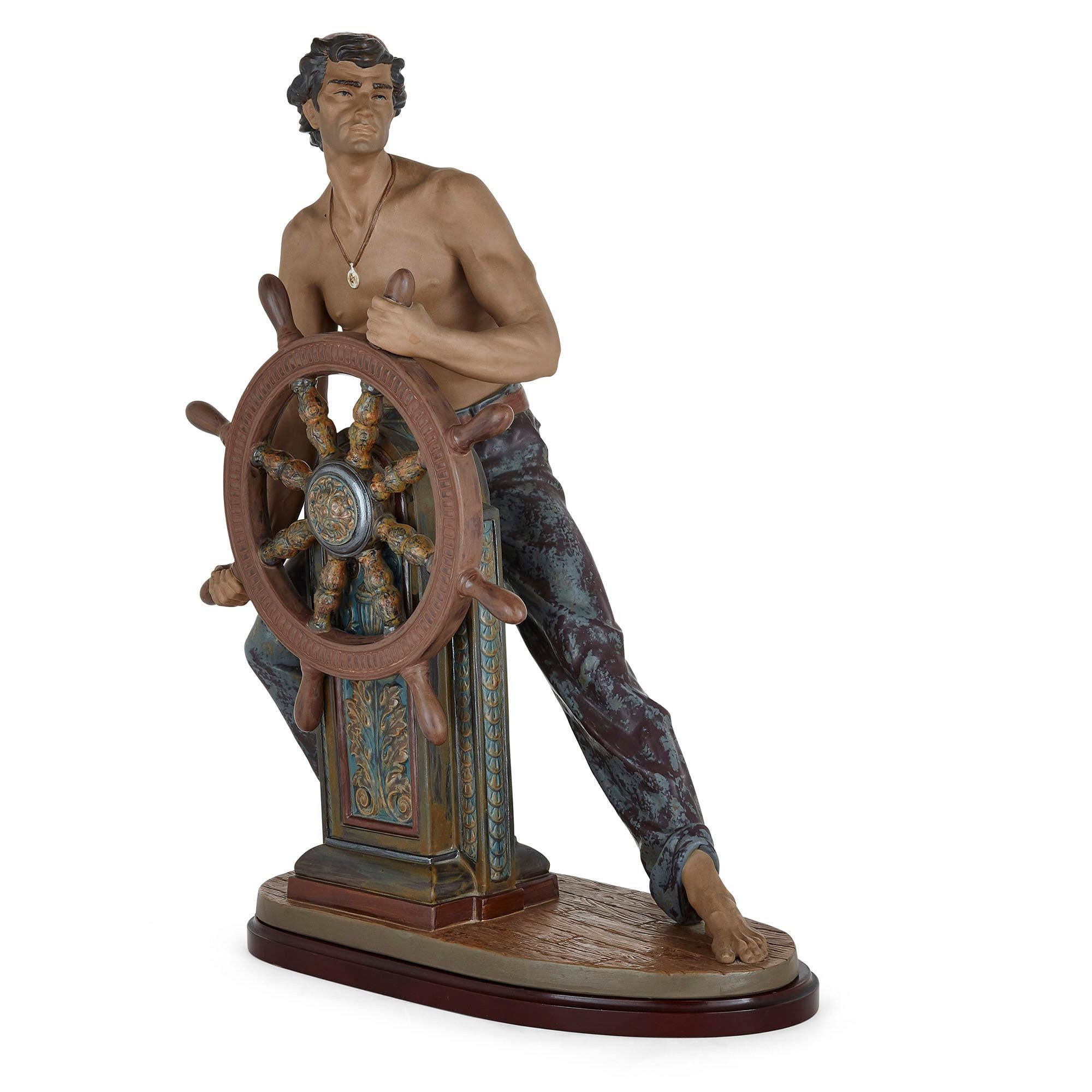 Escultura de cerámica esmaltada de un timonel del fabricante español Lladró
Español, Siglo XX
Medidas: Alto 55cm, ancho 38cm, fondo 20cm

Esta fina escultura de cerámica representa a un timonel en postura heroica. El hombre está de pie, con una