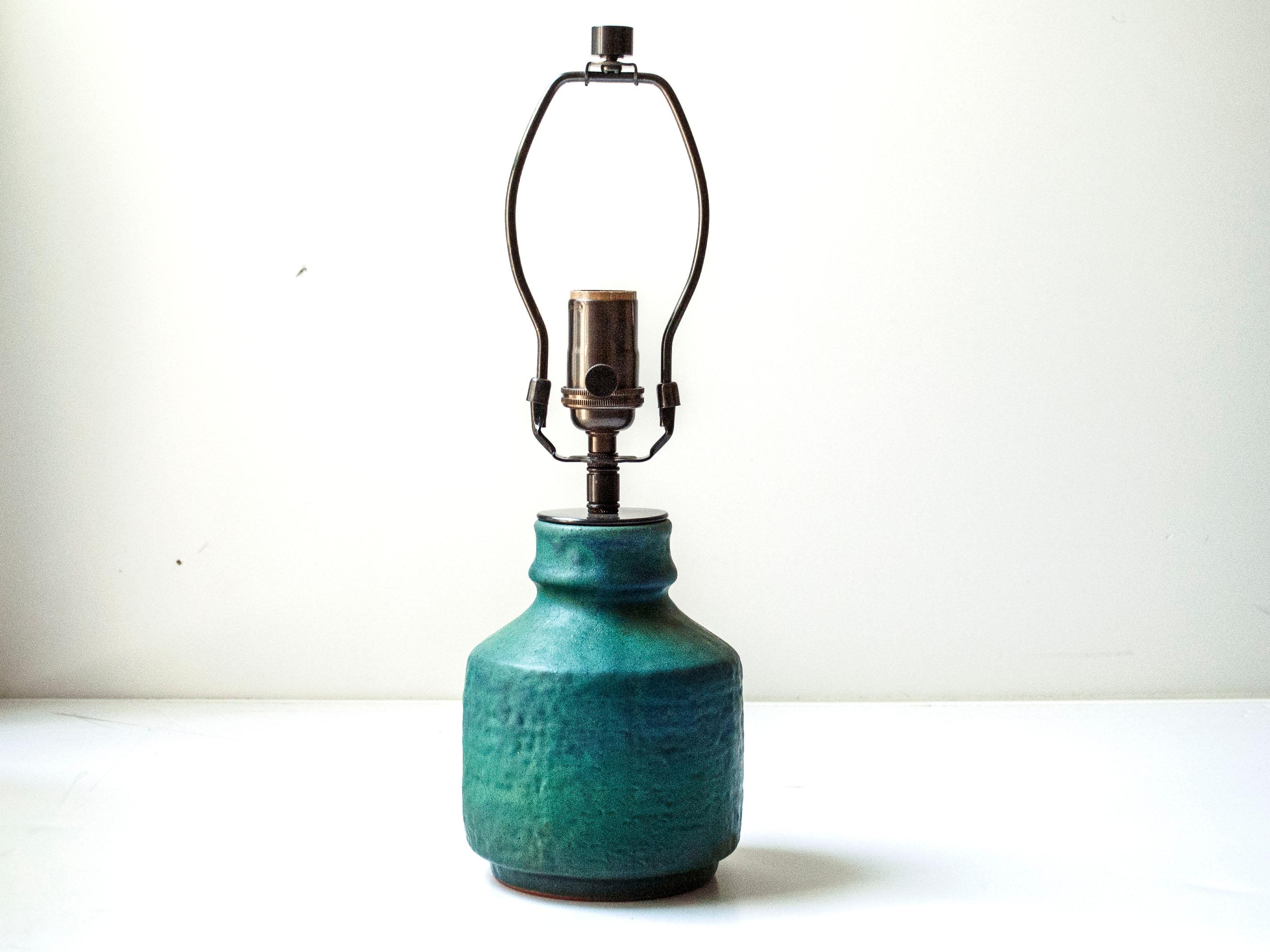Lámpara de sobremesa de cerámica azul oscuro/verde.

Esta lámpara se transformó a partir de un jarrón, sin alterar el propio jarrón. No se taladraron agujeros, y el cable sale del cuello de la lámpara. Cable de seda trenzada negra de 2,5 m de