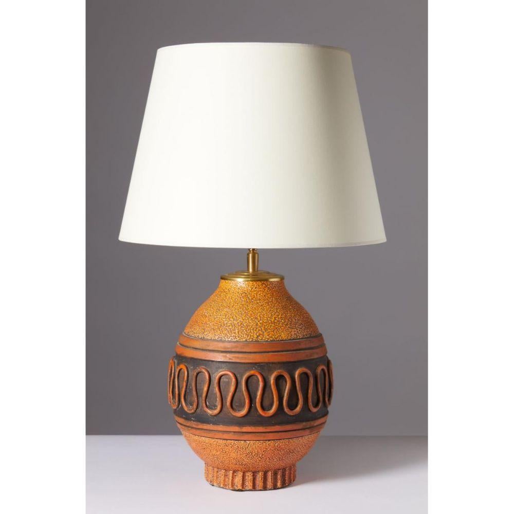 Glazed Ceramic Table Lamp, Keramos, France, c. 1950
Glazed ceramic table lamp, manufactured by Keramos. Vibrant orange and deep brown glazes contrast beautifully on this cool, Greek revival table lamp. 

Original wiring; ready to be rewired. We can