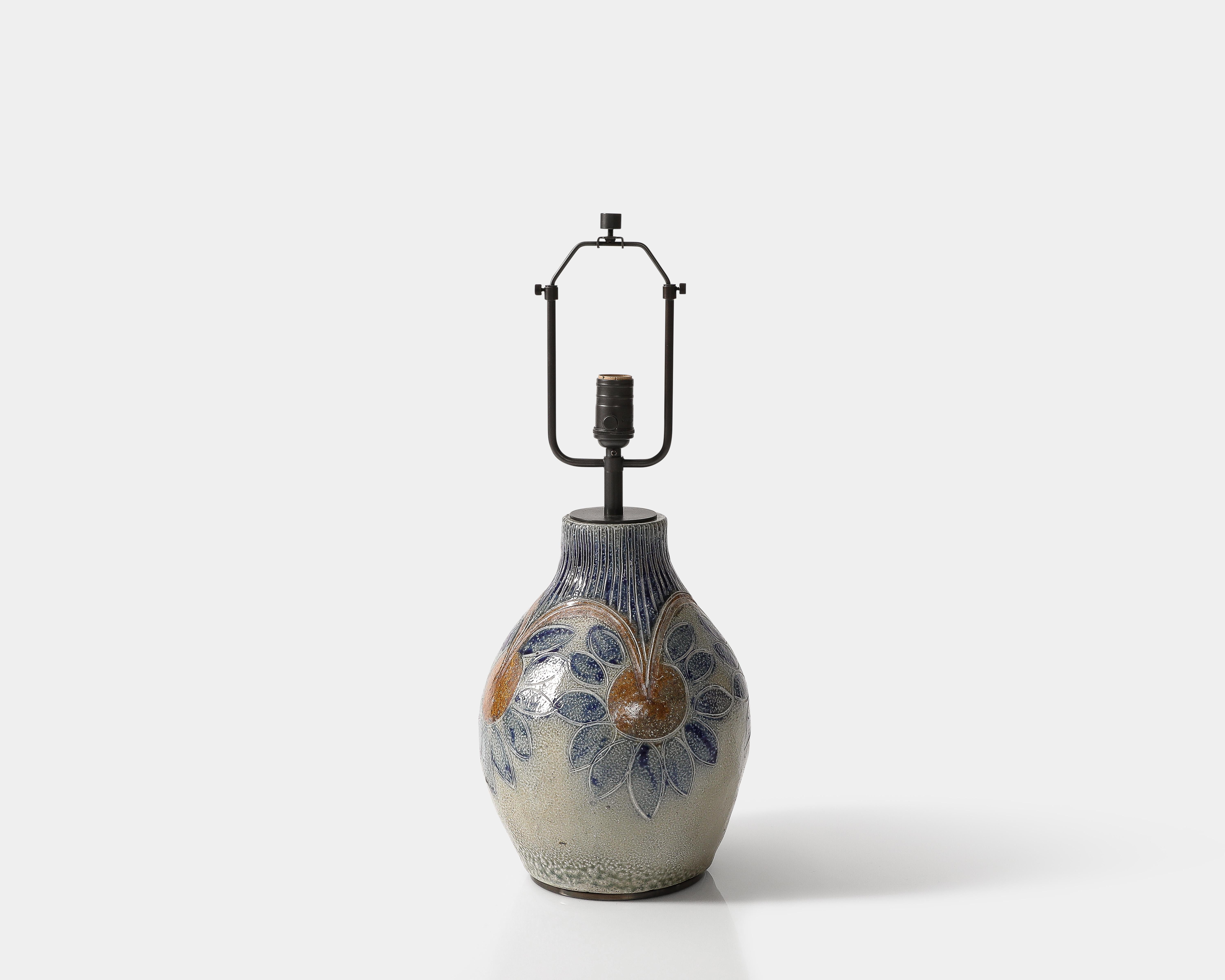 Glazed ceramic table lamp with flower motifs.
