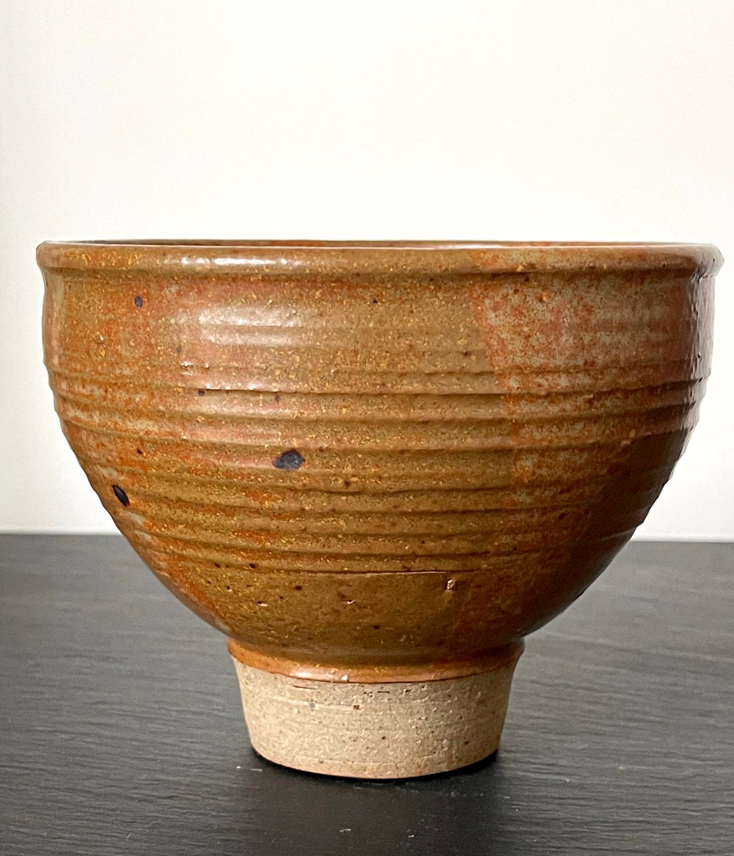 A ceramic tea bowl (chawan) with high foot by Japanese American artist Toshiko Takaezu (American, 1922 - 2011). This particular chawan form is supported by a higher foot rim than usual which was left unglazed intentionally. The well-balanced form is