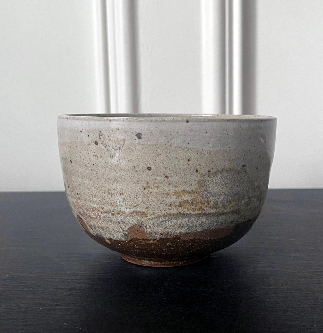 A glazed ceramic tea bowl (chawan) by Japanese American artist Toshiko Takaezu (American, 1922 - 2011). The well-balanced form is hand built and shows slight irregularity, further accentuated with wheel grooves. The surface is covered with