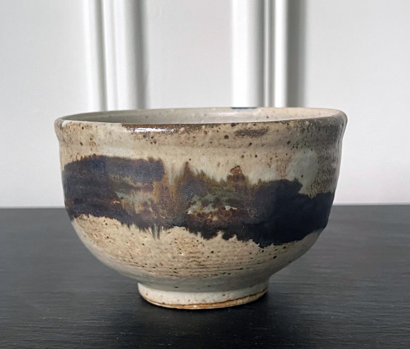 A glazed ceramic tea bowl (chawan) by Japanese American artist Toshiko Takaezu (American, 1922 - 2011). The well-balanced form is hand built and shows slight irregularity, further accentuated with wheel grooves circumventing the exterior. The