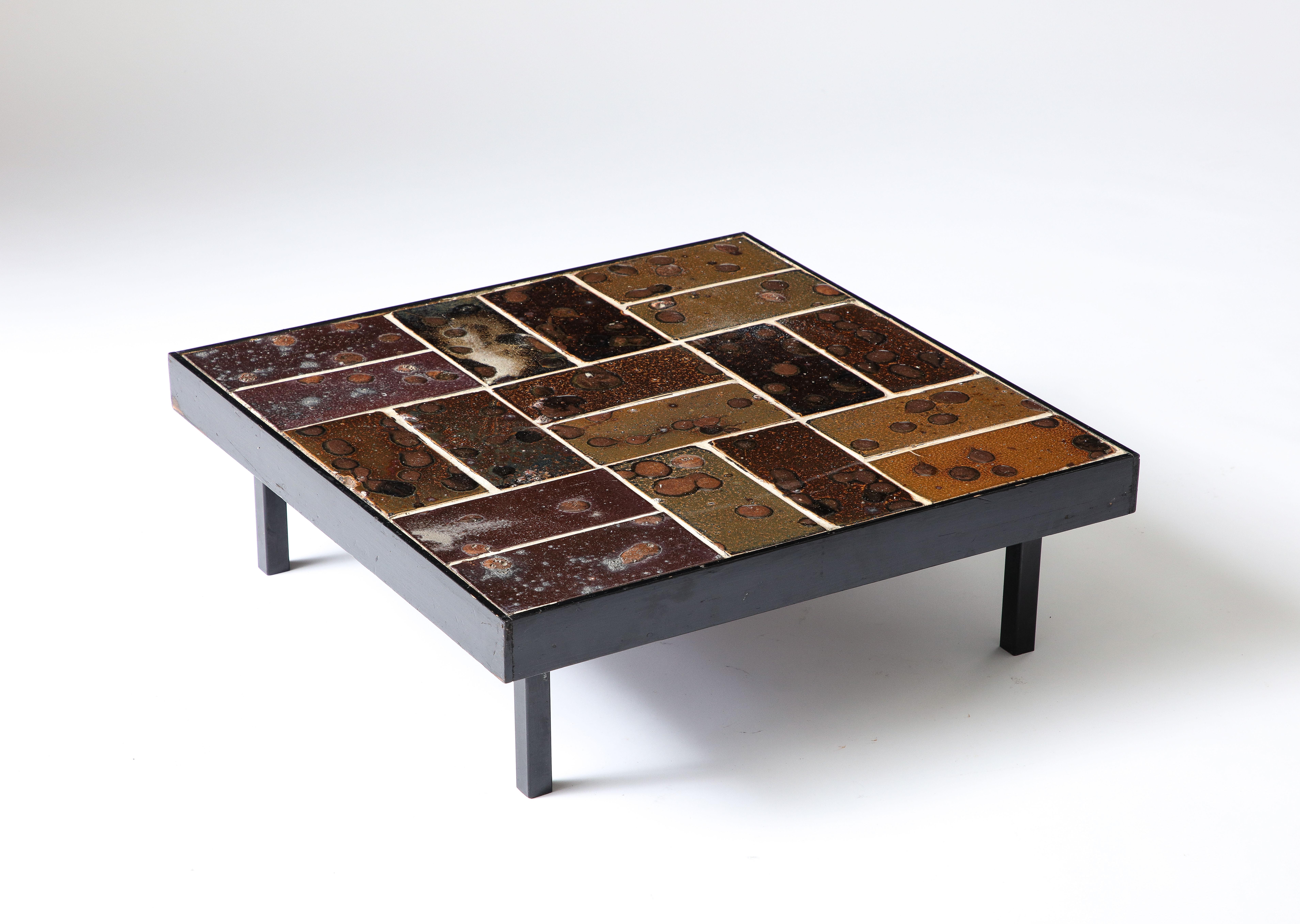 Dieser Tisch besteht aus glasierten Keramikfliesen mit viel Textur und unterschiedlichen Farbtönen. Ein solides, auffälliges Stück.