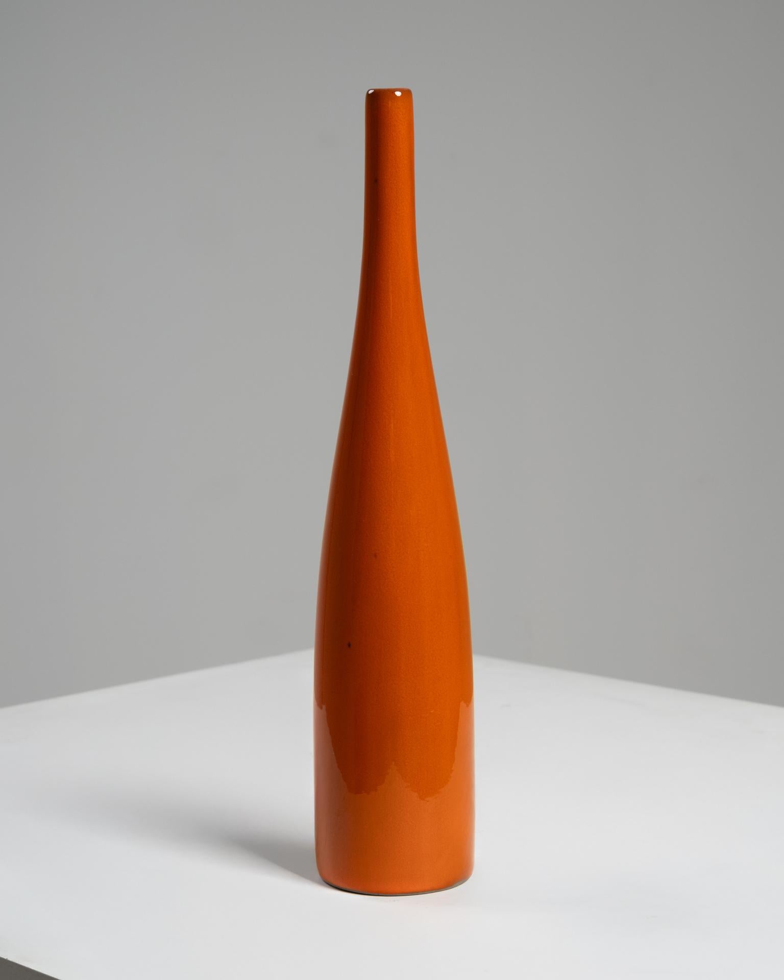 Ce vase en céramique émaillée de Jacques (1926-2008) et Dani (1933-2010) Ruelland, célèbres céramistes français, a été créé en France vers 1960. Cette pièce élégante et élancée mesure 32 cm de haut pour un diamètre de 6,5 cm, et présente l'équilibre