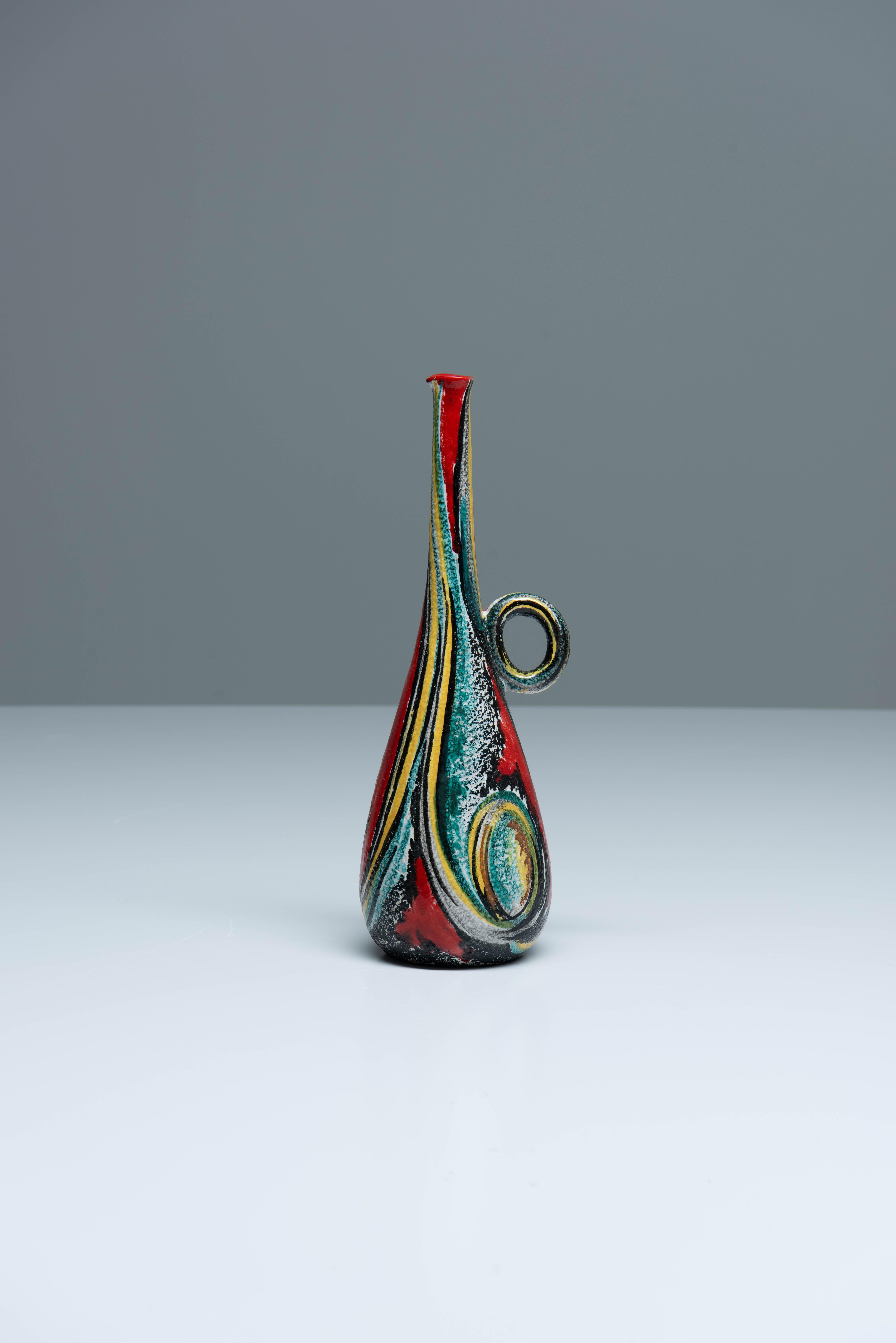 Vaso in ceramica smaltata con motivi astratti e colorati, manico rotondo e collo lungo e sottile.
Firmato 
