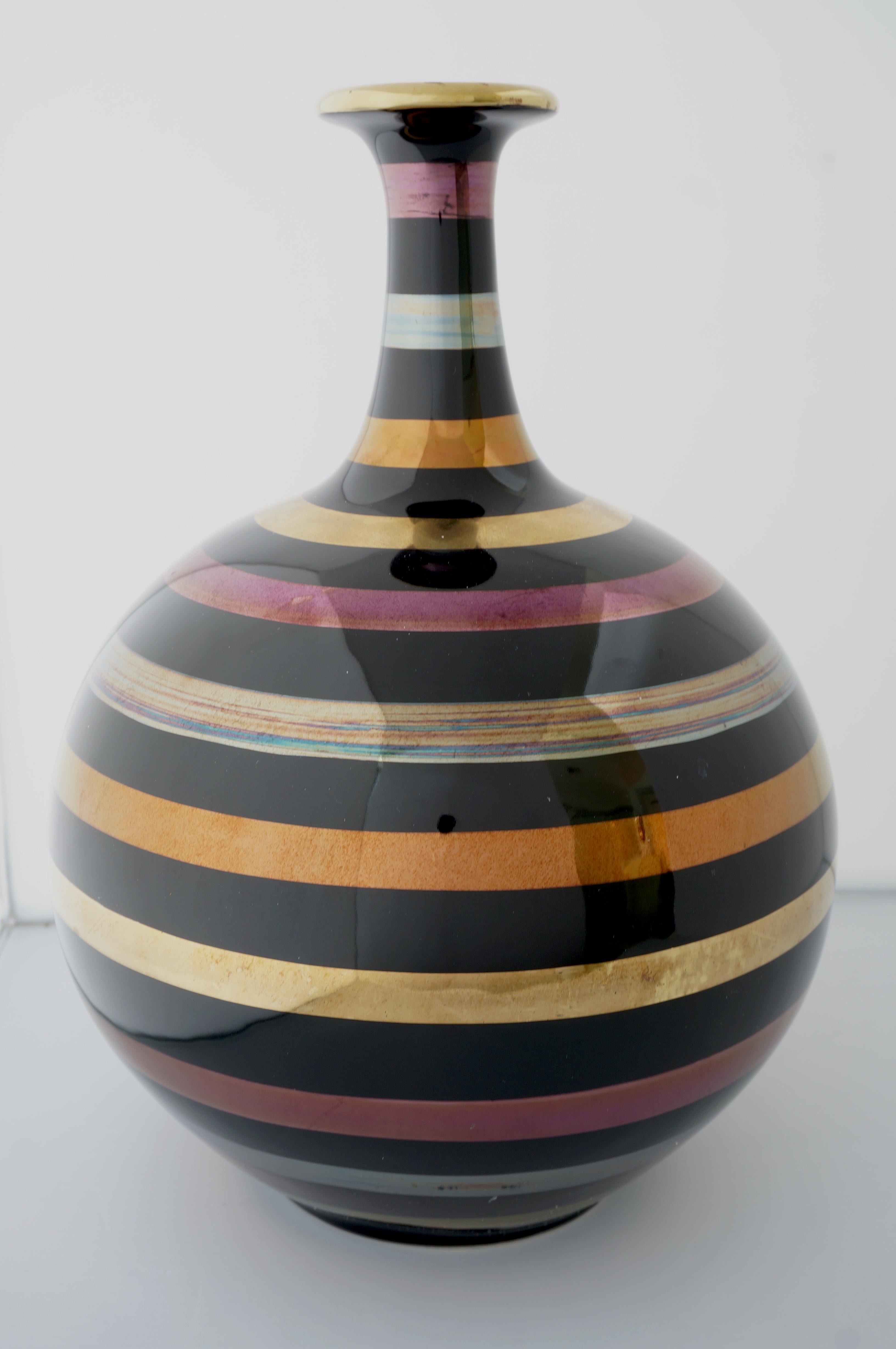 This stylish and chic glazed ceramic vase is is finished with bands of 24k gold, silver and copper.  The piece makes a subtle statement with its form and use of materials.  