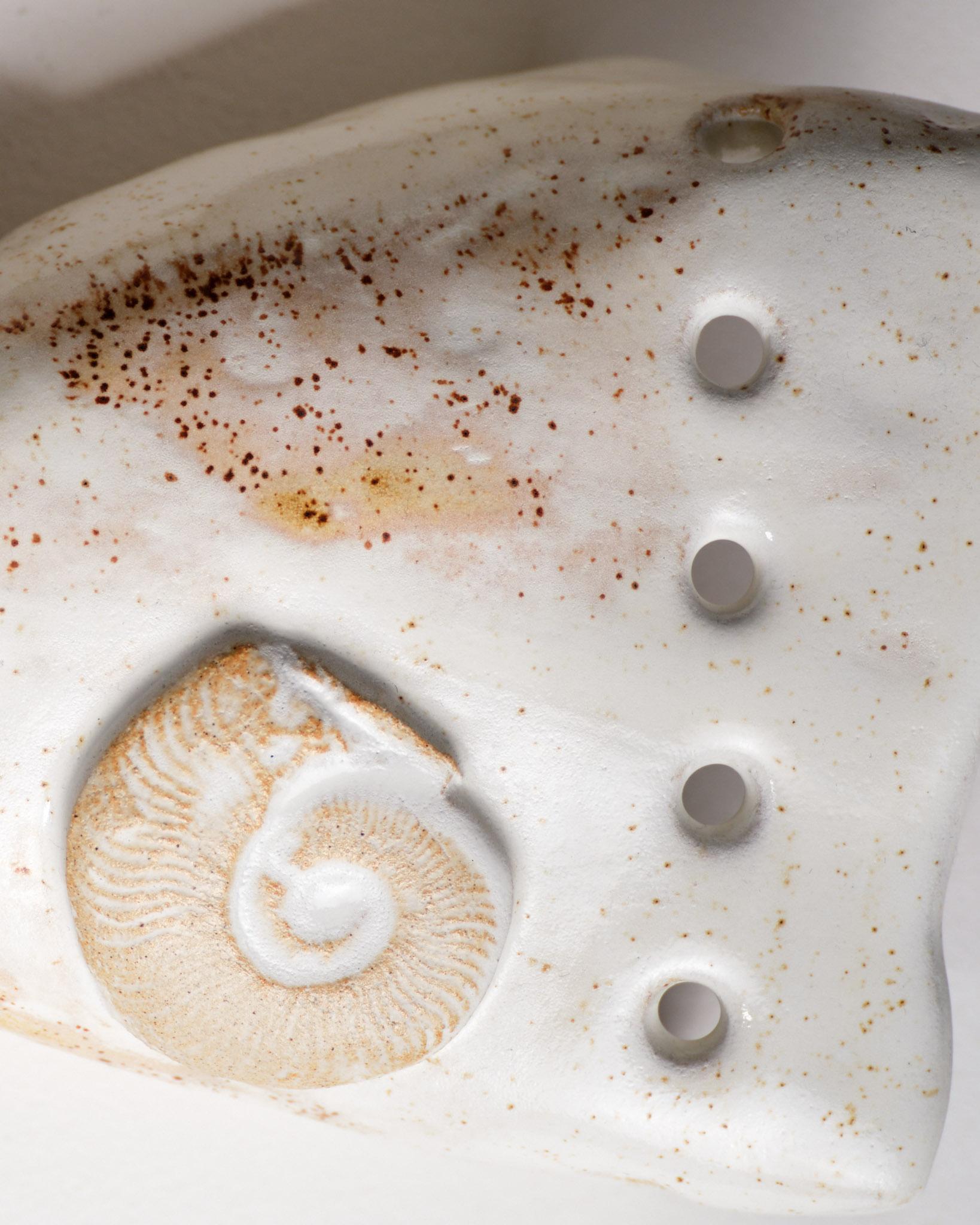 Aplique de cerámica esmaltada de Bérénice Gentil, adornado con motivos inspirados en el mundo marino: conchas, corales y texturas naturales. Su relieve orgánico y su acabado blanco brillante aportan un toque escultural y luminoso a cualquier